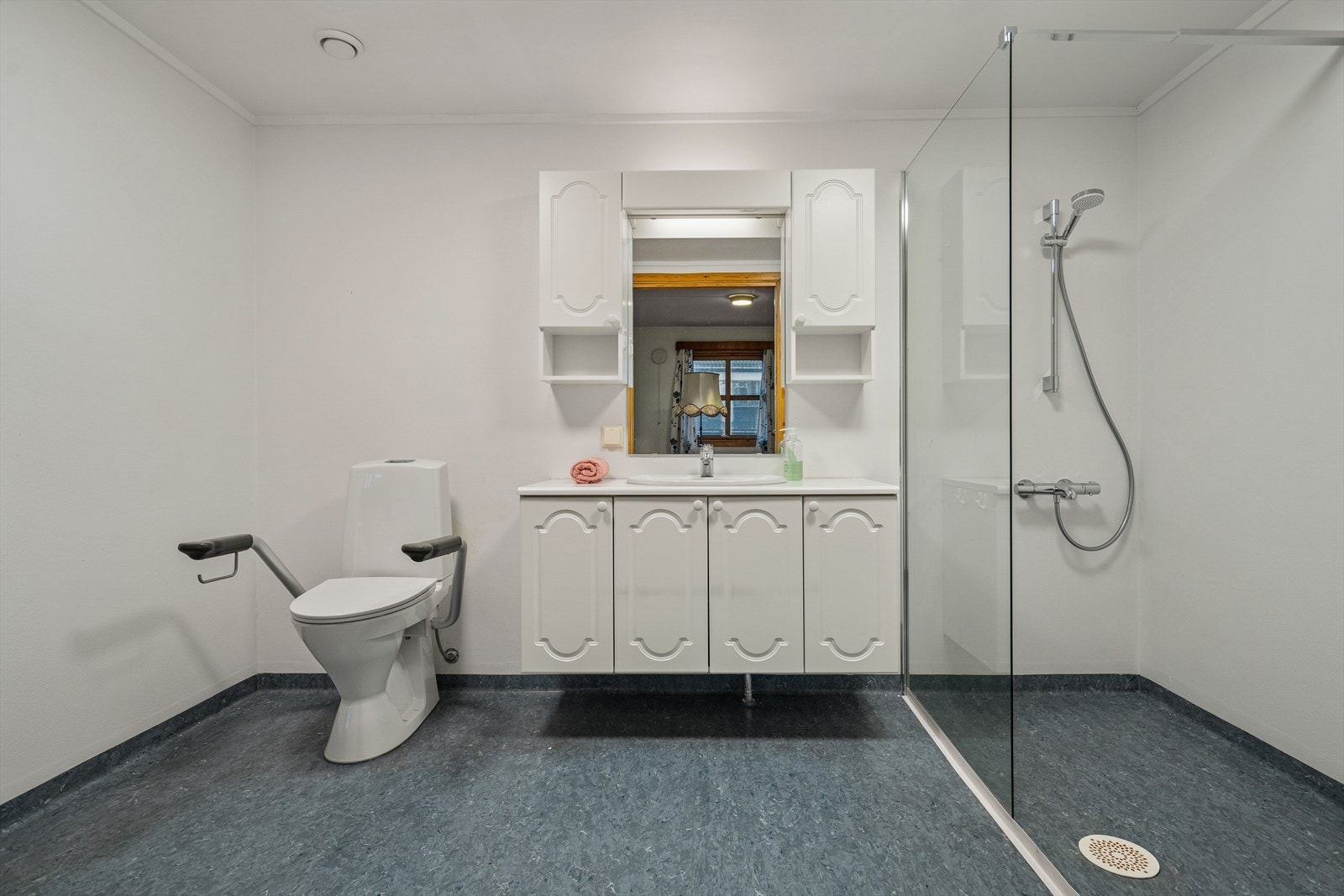 Rommet er utstyrt med gulvstående toalett, innredning og dusjvegg. Det er opplegg for vaskemaskin. Galleribilde