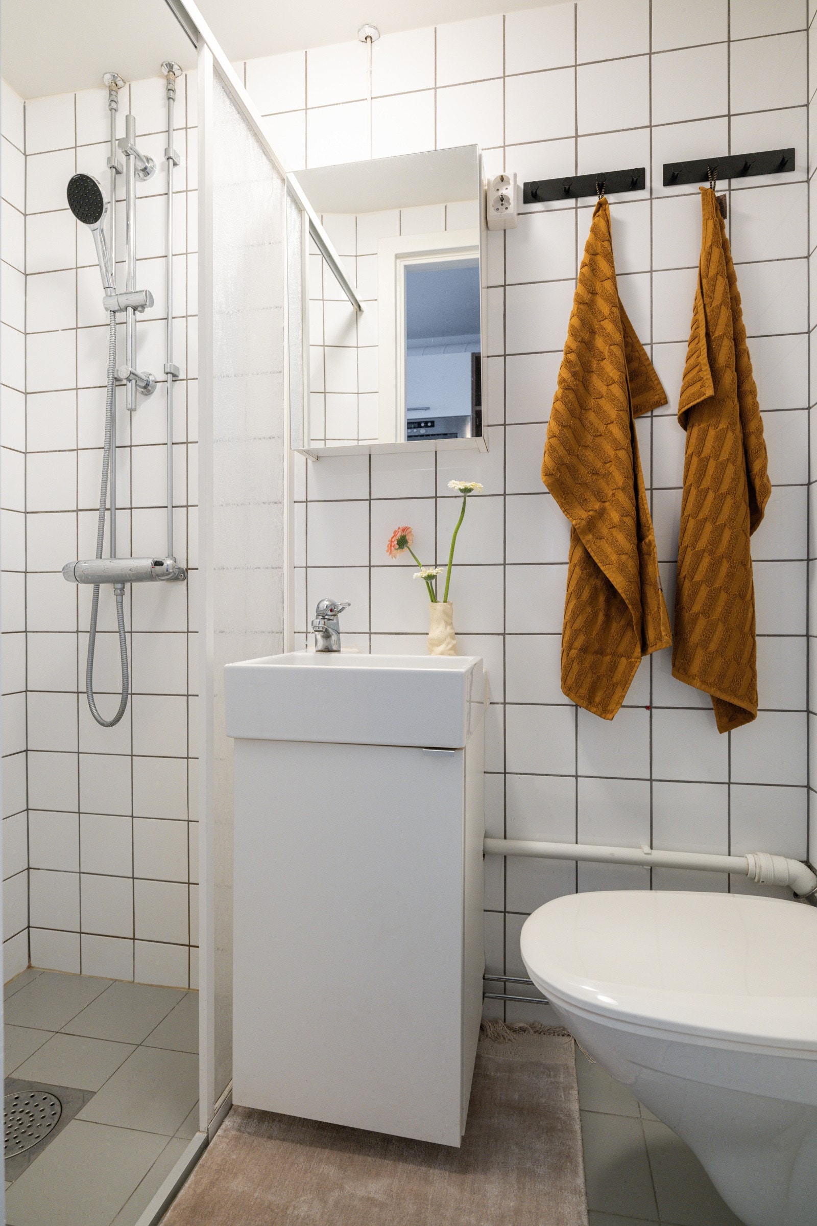 Baderommet er utstyrt med lyst servantskap med speilskap over, dusjnisje med delevegg og vegghengt toalett. Galleribilde