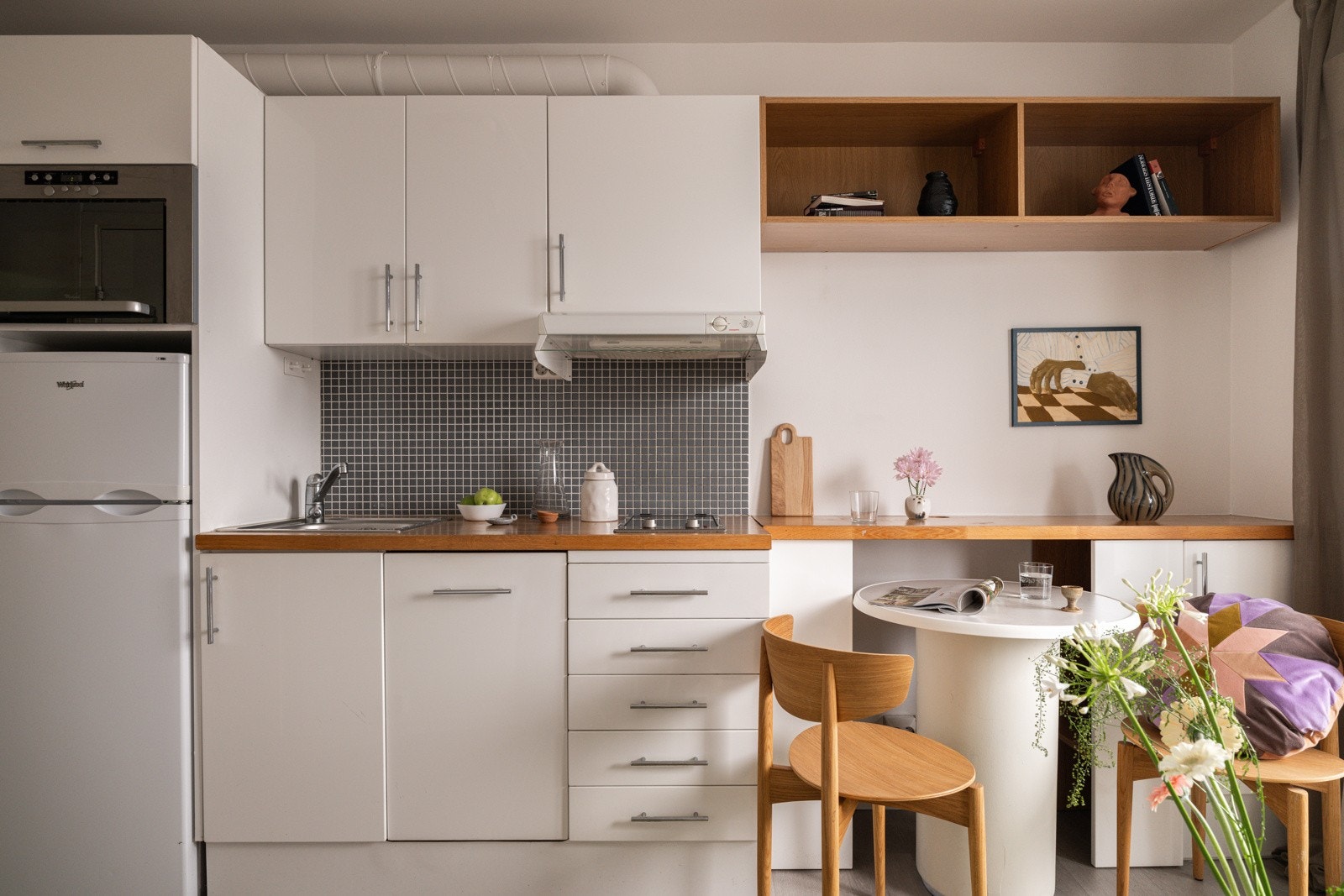 Lys og pen kjøkkeninnredning fra 2008 med hvite glatte fronter og heltre benkeplate i eik med nedfelt oppvaskkum. Galleribilde