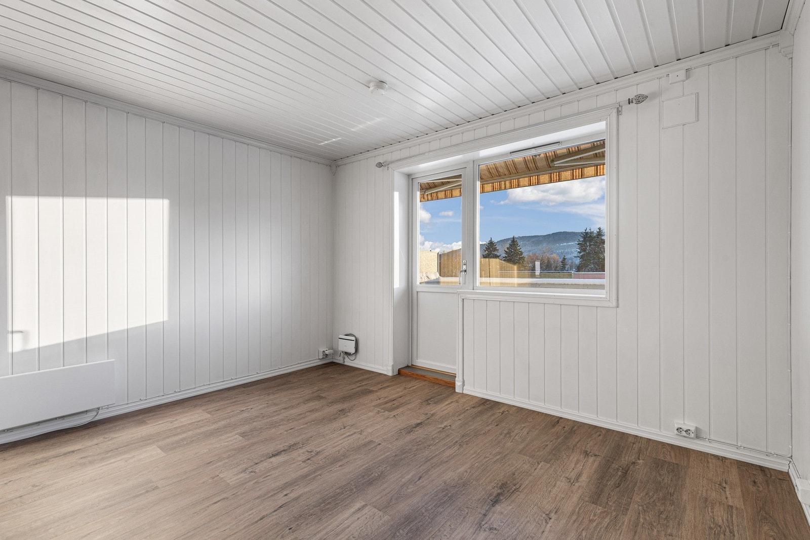 Stuen har store vindusflater som gir rommet mye naturlig lys. Galleribilde