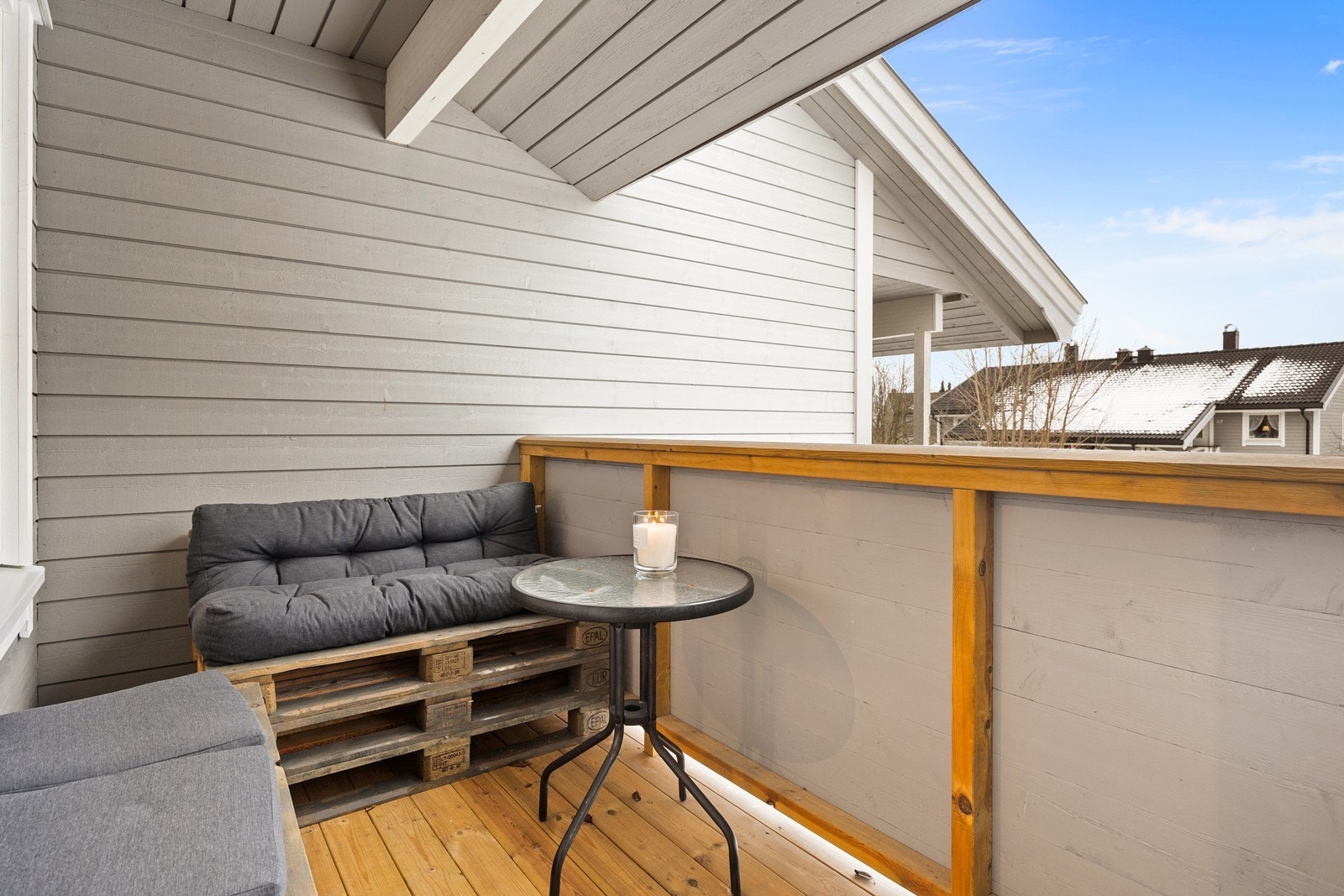 Romslig vestvendt balkong med pallesofa og stemningsfullt sitteområde Galleribilde