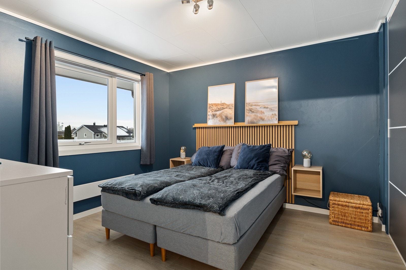 Hovedsoverommet byr på en lun og avslappende stemning med mørkeblå vegger, spilevegg som elegant hodegavl og rikelig med naturlig lys fra stort vindu. Galleribilde