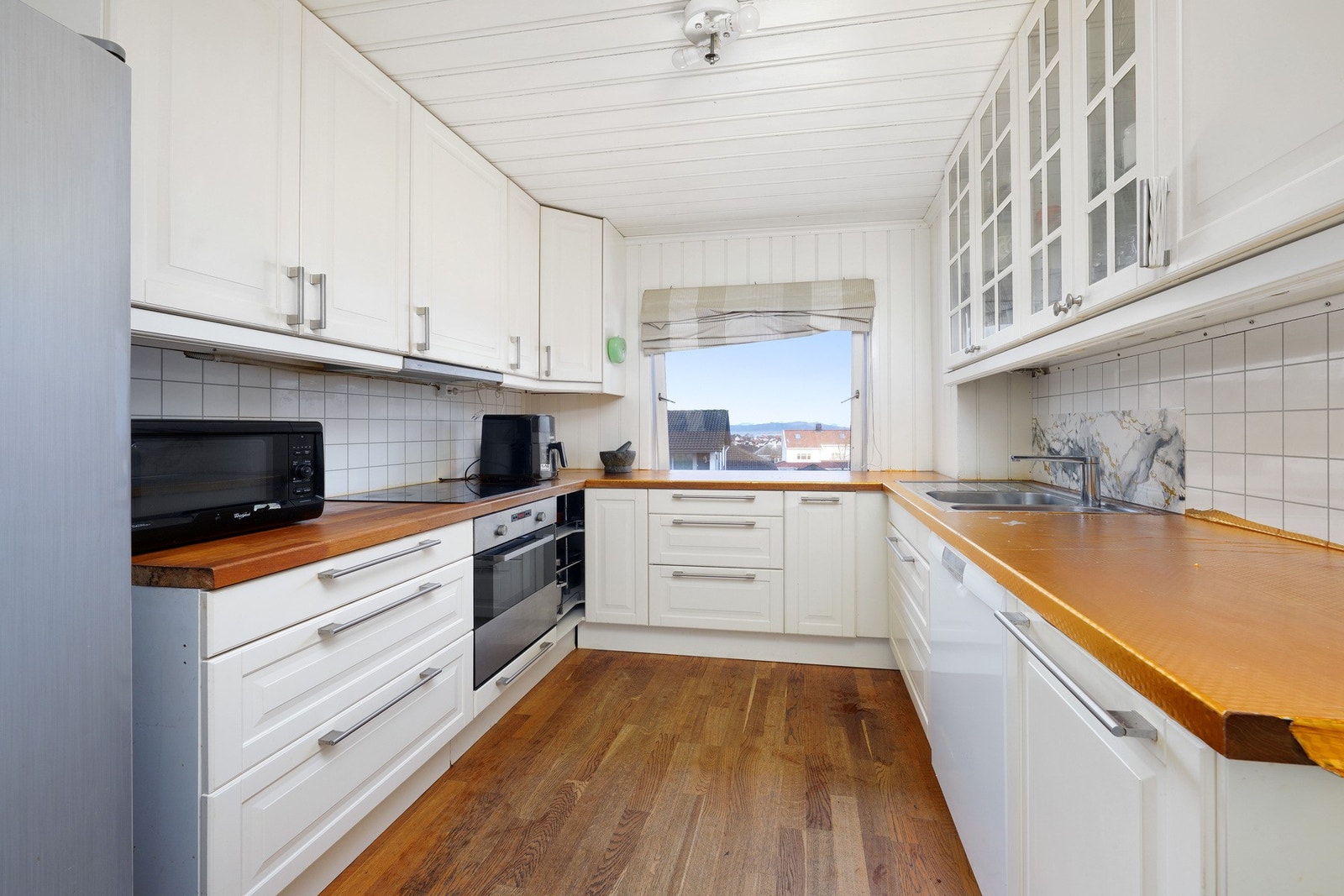 Kjøkkenet er fra 2011, med hvite fronter og parkett på gulv. Det er godt med oppbevaring- og benkeplass. Galleribilde