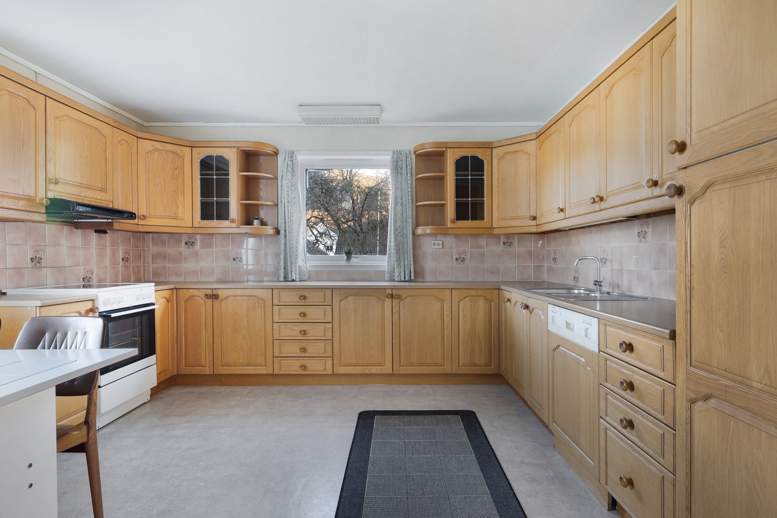 Romslig kjøkken med klassisk eikekjøkken og rikelig med skap- og benkeplass. Galleribilde