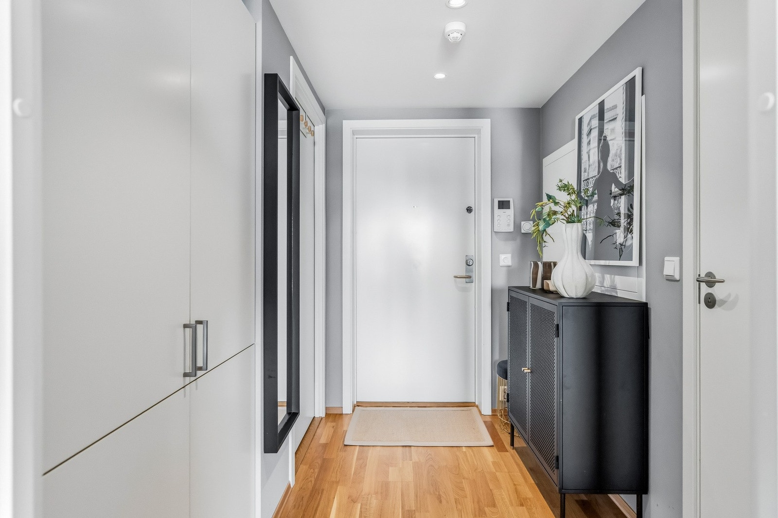 Romslig og innbydende entré med trestavsparkett på gulvet og lyse, tidsriktige farger på veggene. Videre har entréen vannbåren gulvvarme og spotter i himlingen. Galleribilde