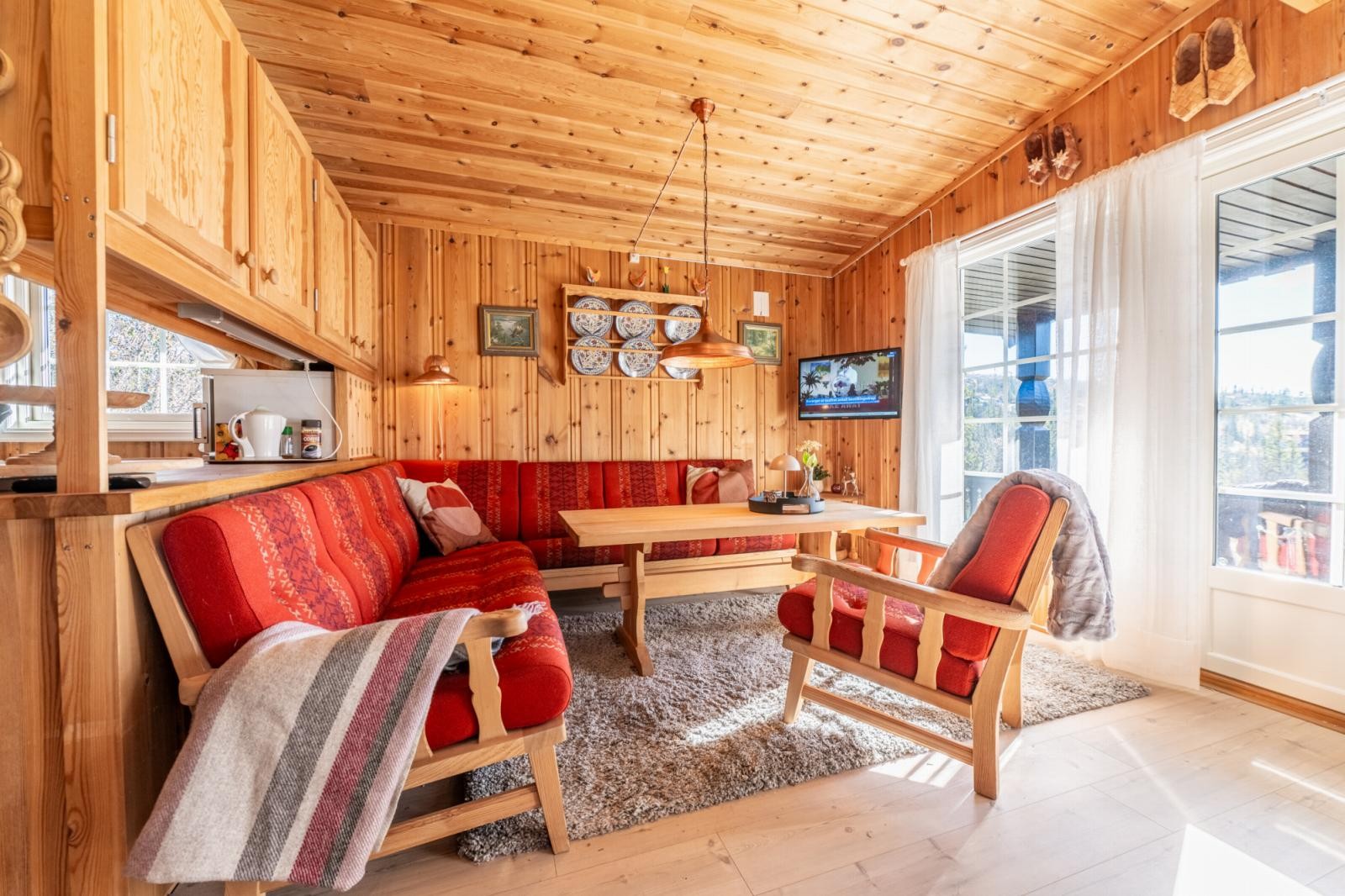 God plass til stor sofaseksjon i tilknytning til store vindusflater og adkomst til terrasse Galleribilde