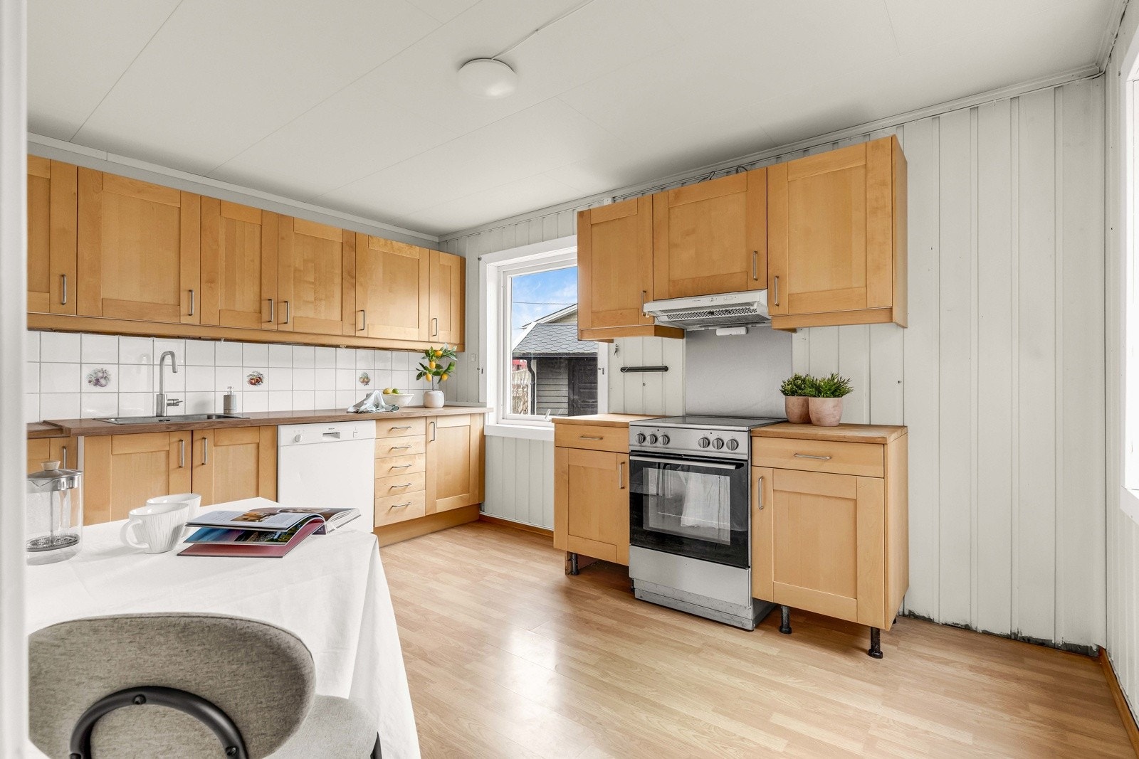 Kjøkkenet har en eldre, men velholdt innredning med god skap- og benkeplass. Vinduet gir fint dagslys og gjør rommet lyst og trivelig. Galleribilde