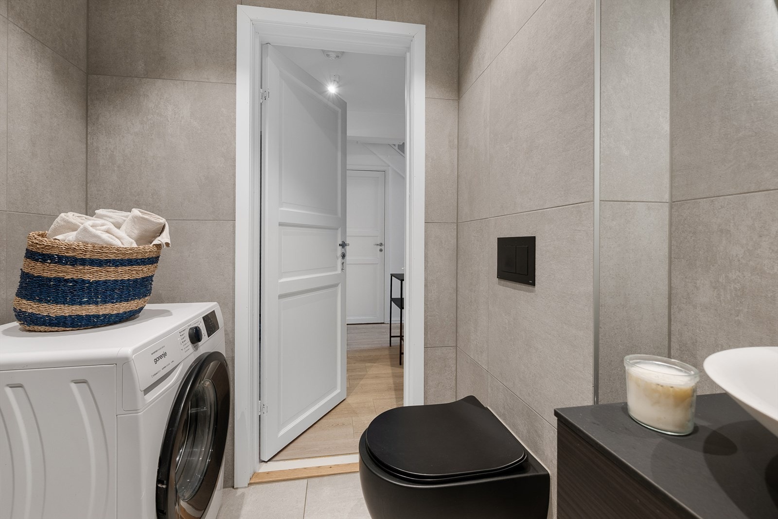 Badet har vegghengt toalett og opplegg for vaskemaskin. Galleribilde