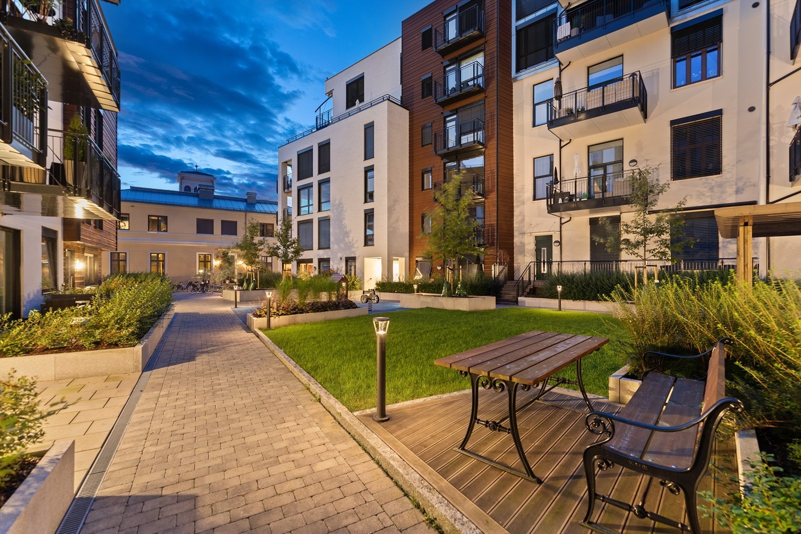 Flott opparbeidet med belegningsstein, gressplen og sittebenker Galleribilde