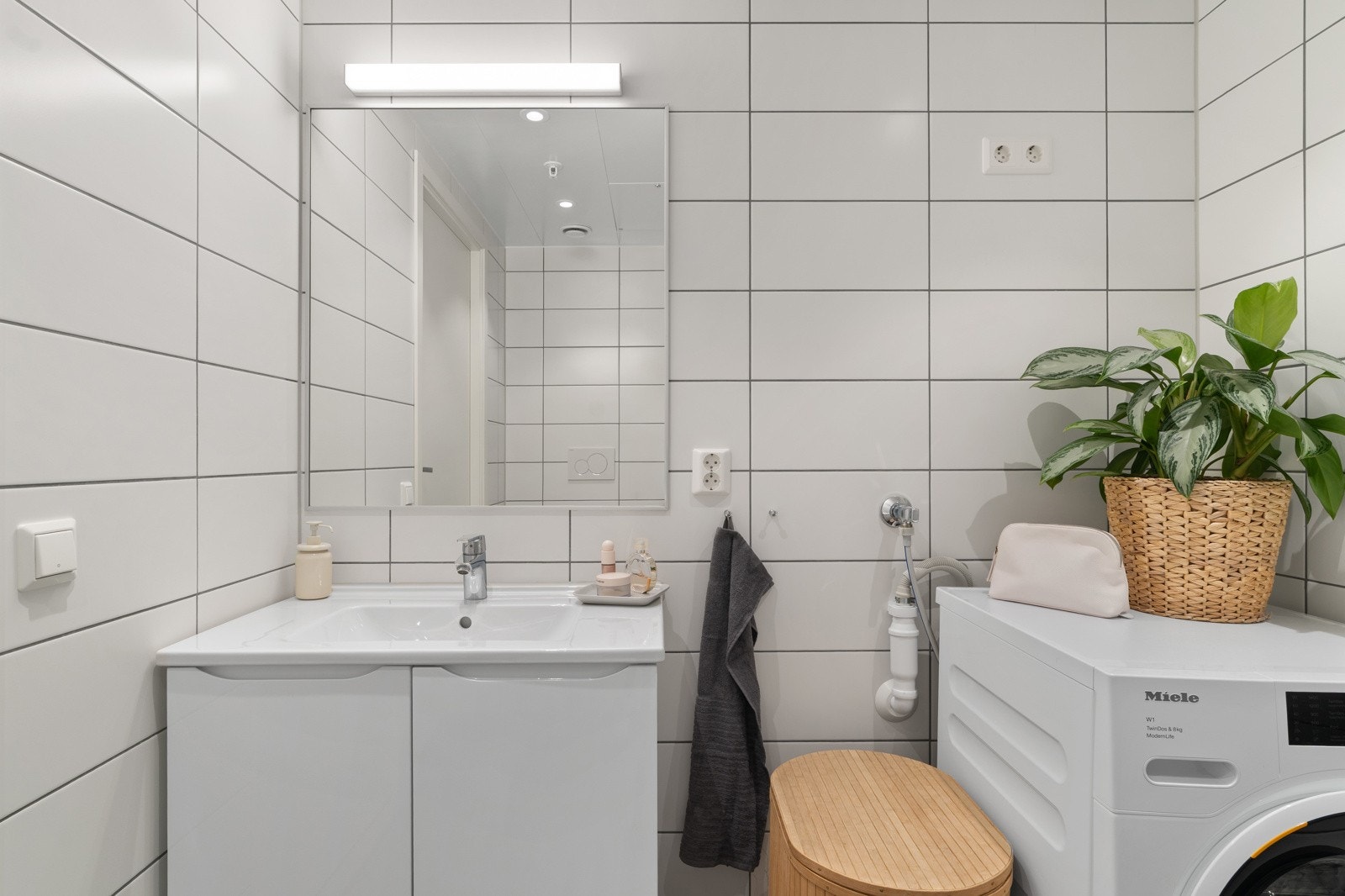 Baderomsinnredningen består av servant med underskap i hvit utførelse, og speil med lysarmatur over. Galleribilde