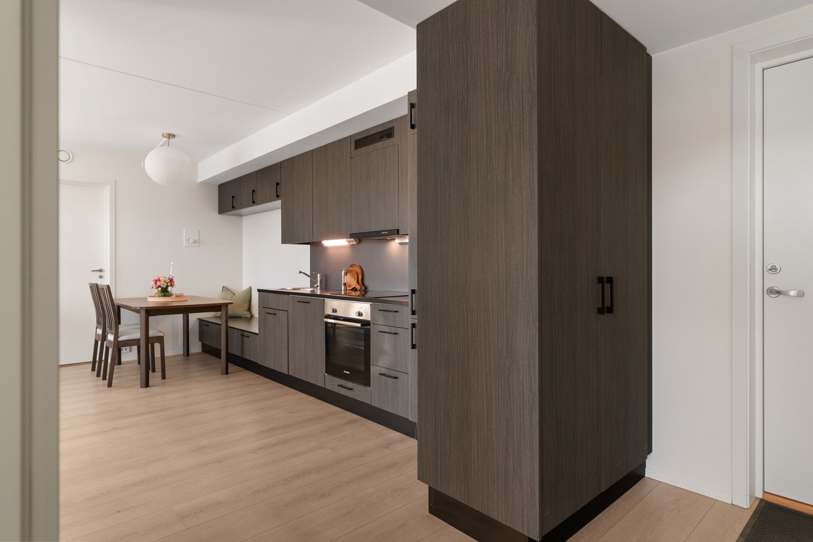 Skapet i gangen fungerer som romdeler mot kjøkkenet, og har fronter i samme utførelse som kjøkkeninnredningen. Galleribilde