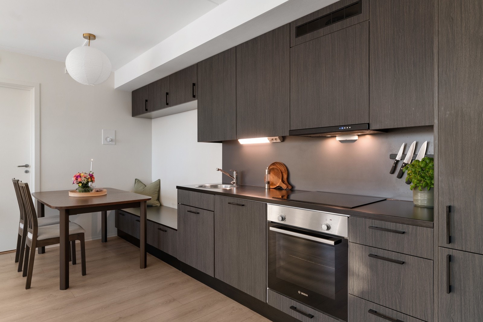 Kjøkkeninnredningen er i en tidsriktig, mørk utførelse og består av består av underskap, skuffer og veggskap. Galleribilde