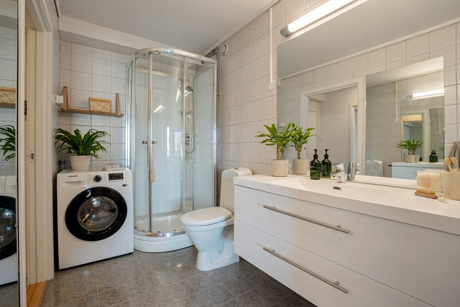 Badet er svært romslig og innredet med dusjkabinett, servant med underskuffer og god oppbevaringsplass. Det er også opplegg for vaskemaskin. Galleribilde