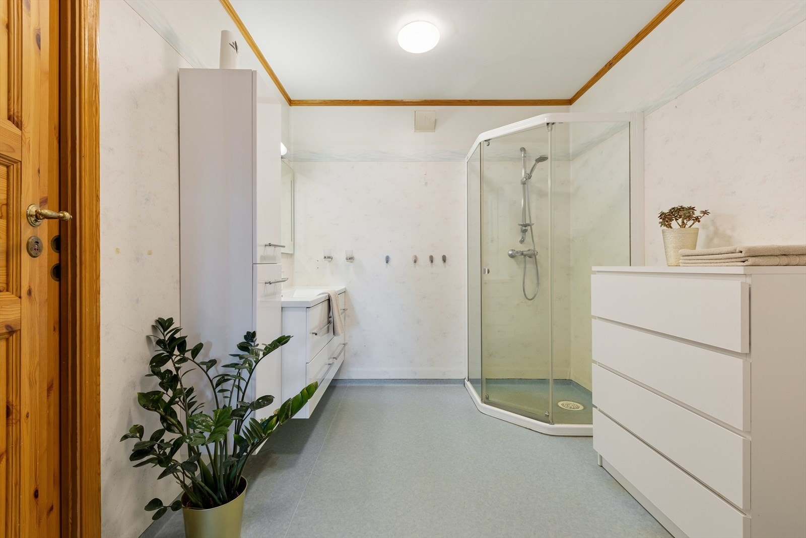 Baderommet er fra byggeår og er innredet med blått vinylbelegg på gulv og mønstrete våtromstapet på vegg. I gulvet har man også varmekabler for ekstra komfort. Galleribilde