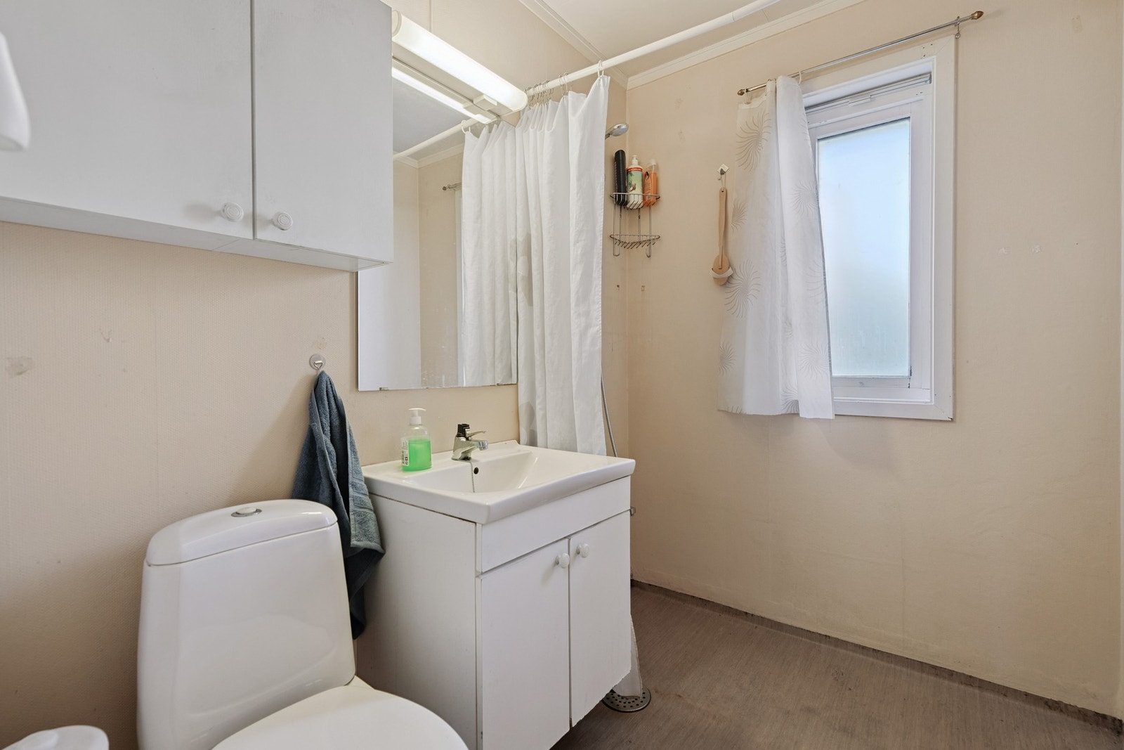 Bad med gulvbelegg, strietapet på vegg og malte plater på tak Galleribilde