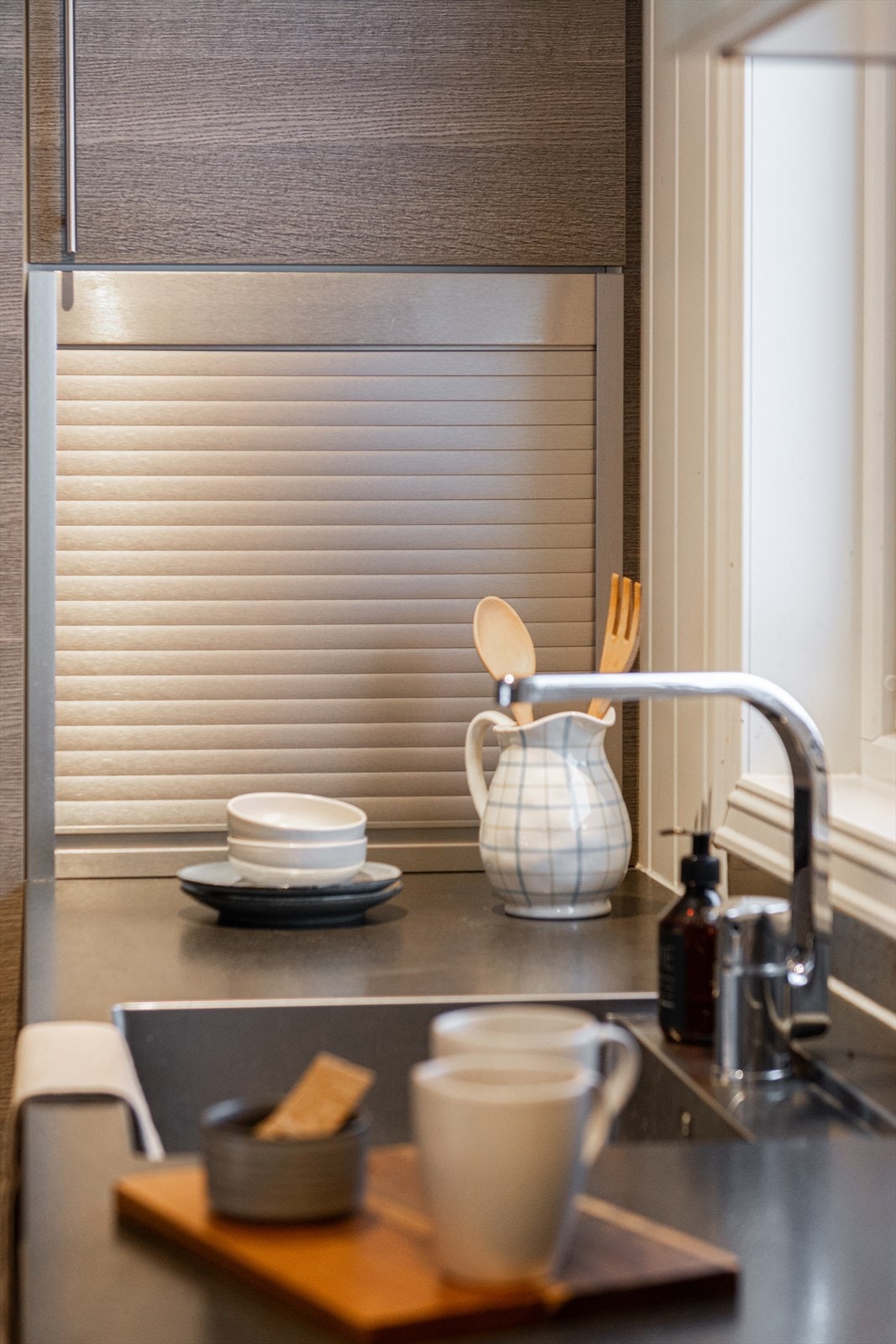 Ettgreps blandebatteri og praktisk oppbevaring på kjøkkenbenken. Galleribilde