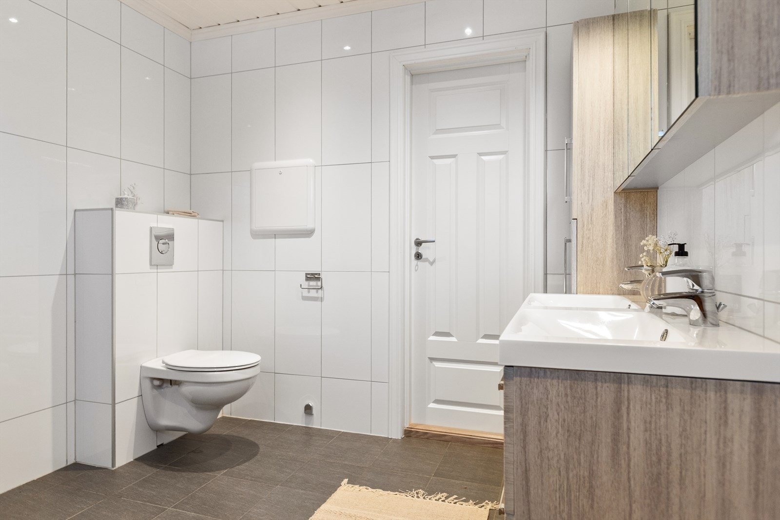 Badet har vegghengt toalett og elektriske varmekabler i gulvet for komfort. Galleribilde