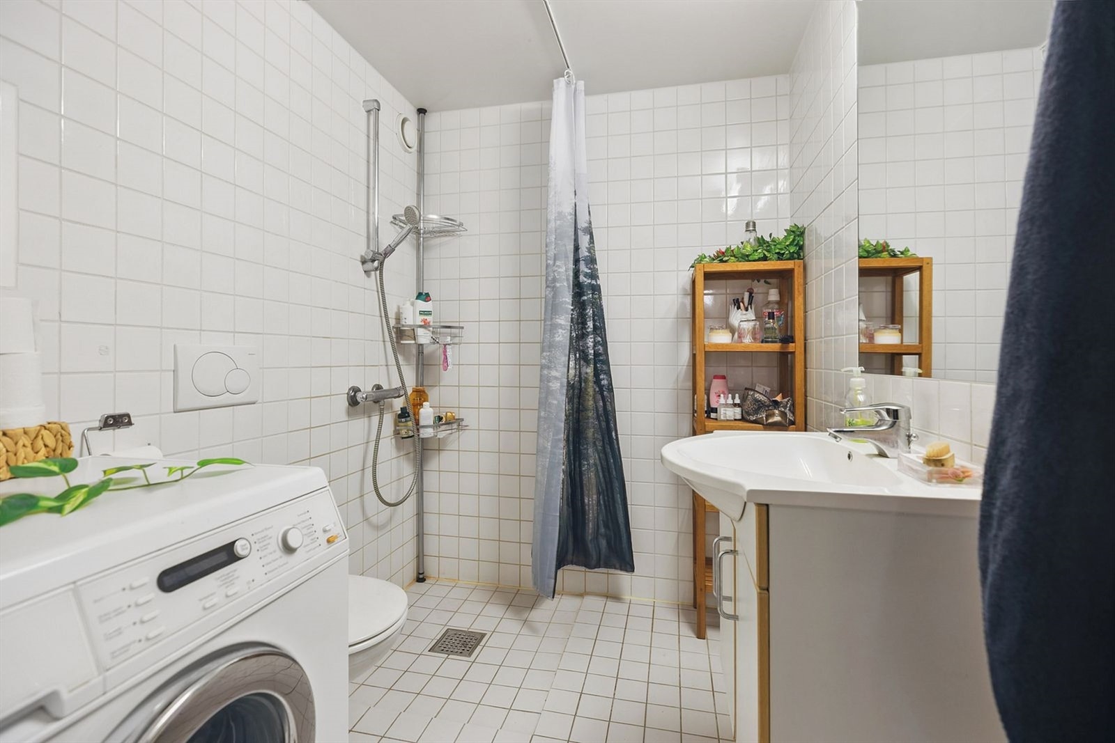 Pent flislagt bad med servant, speil, dusj, wc og vaskemaskin. Galleribilde