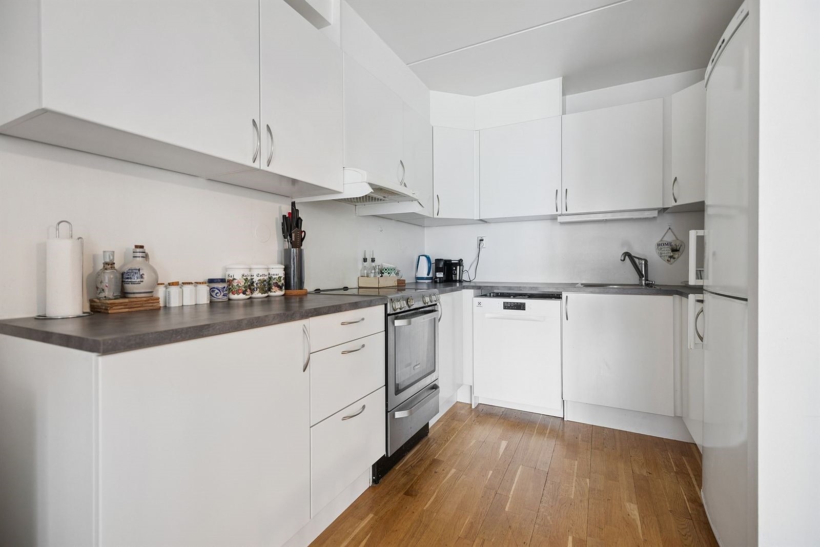 Lyst kjøkken med hvite fronter. Hvitevarer medfølger ikke. Galleribilde