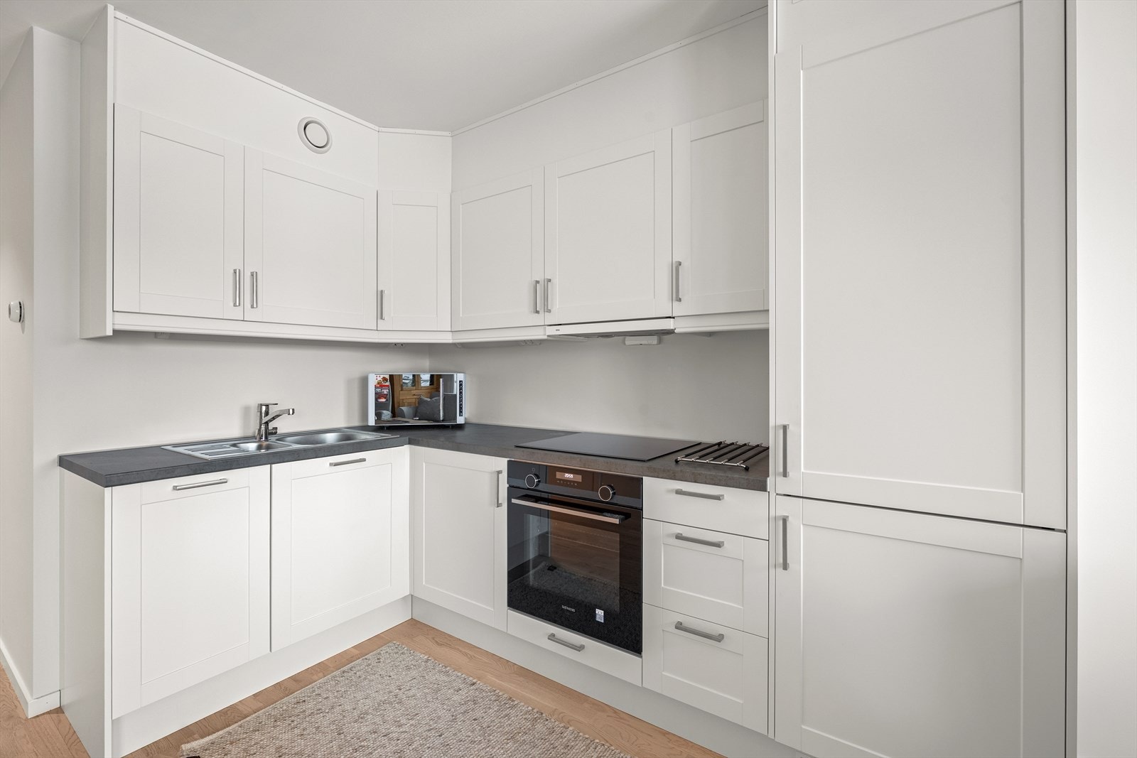 Integrerte hvitevarer med kjøle-/fryseskap, platetopp, komfyr og oppvaskmaskin. Galleribilde