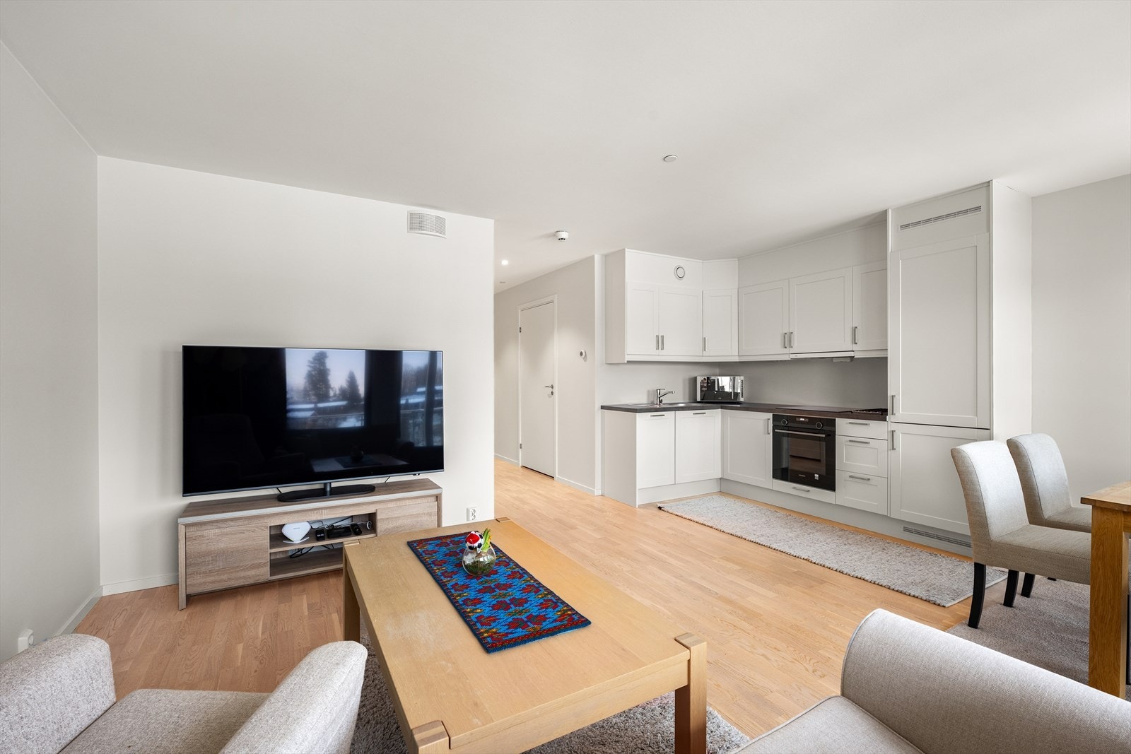 Parkett i stue, kjøkken, gang, bod og soverom. Veggflatene er i en lys fargepalett. Galleribilde