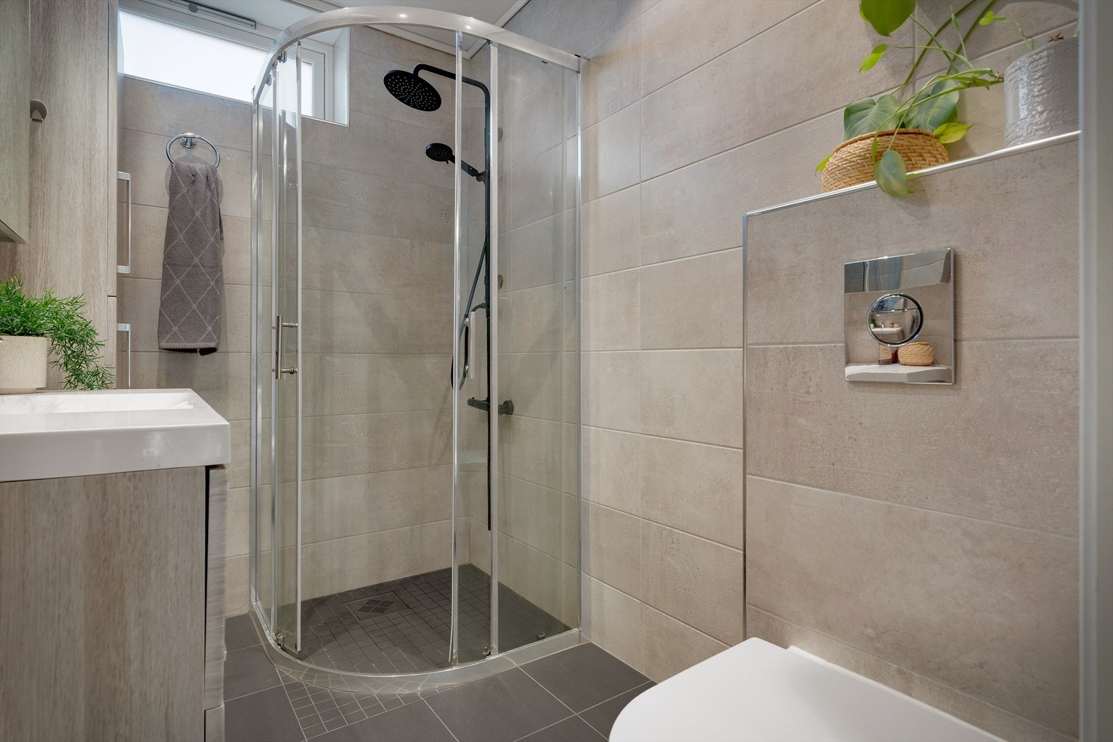 - Badet inneholder servant m/møblement, høyskap, vegghengt toalett og buet dusjhjørne i glass - Galleribilde