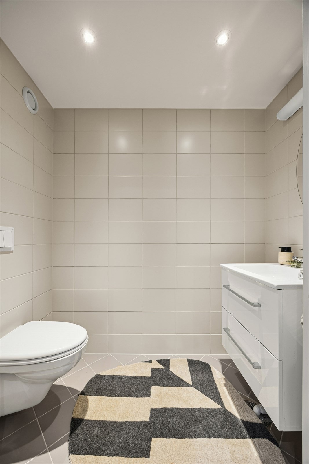 Leiligheten har et separat WC som også ble tatt i 2017, med flislagte overflater, vegghengt toalett og servant. Galleribilde