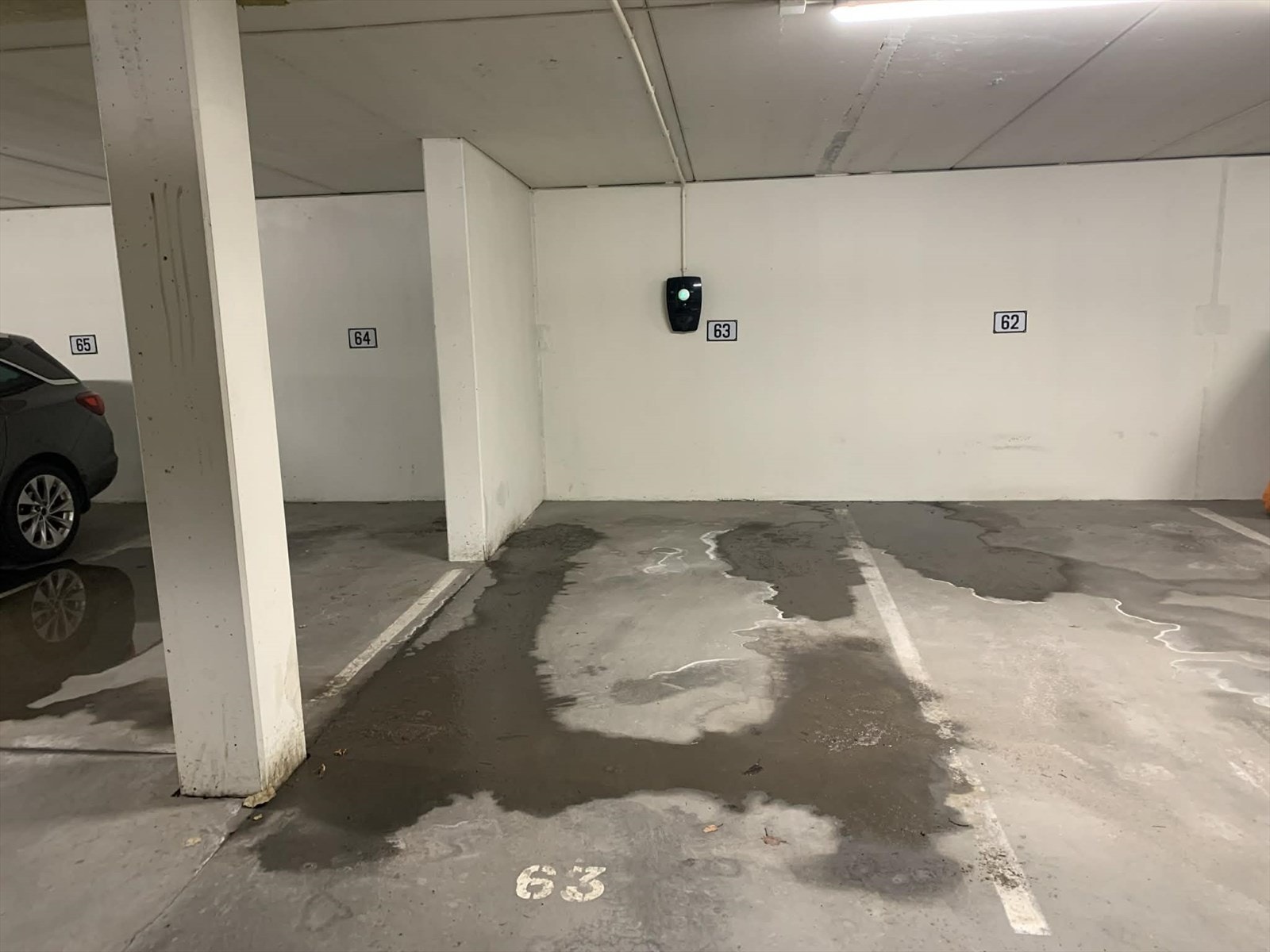 Garasjeplass nr 63. Vann som er synlig på plassen er kun smeltet snø fra bil som har stått der. Galleribilde