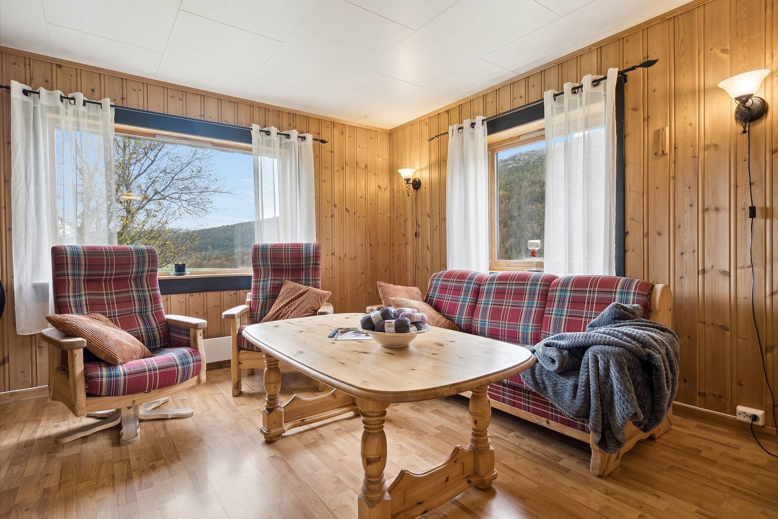 Store vindusflater i deler av stuen slipper godt med lys inn Galleribilde