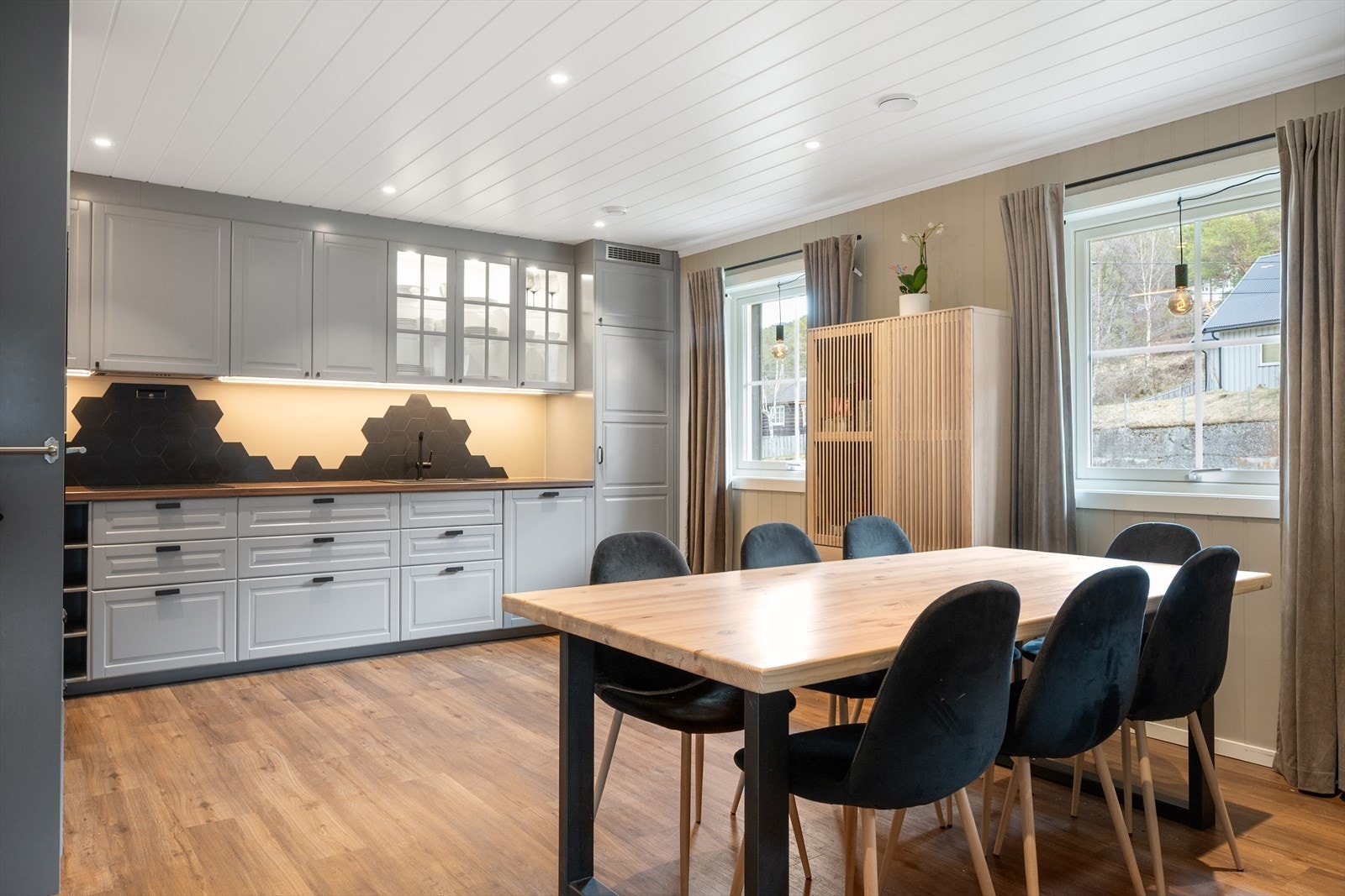 Kjøkkenet har en tidløs, klassisk og takhøy innredning i grå utførelse. Galleribilde