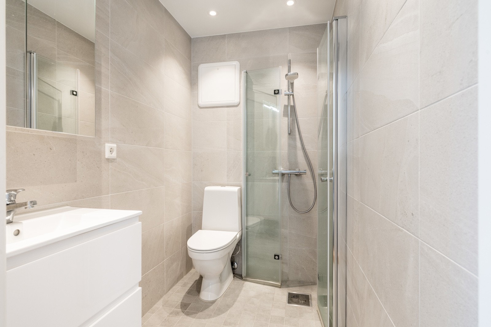 Badet i leiligheten fremstår meget innbydende med lekre fliser på flatene og downlights i himlingen Galleribilde