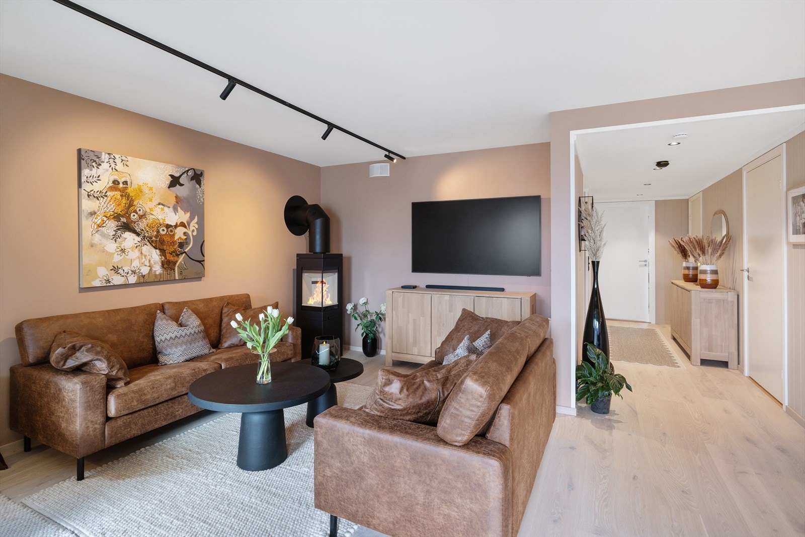 Stuen er lys og innbydende med parkett på gulv og delikat farge på slette vegger. Galleribilde