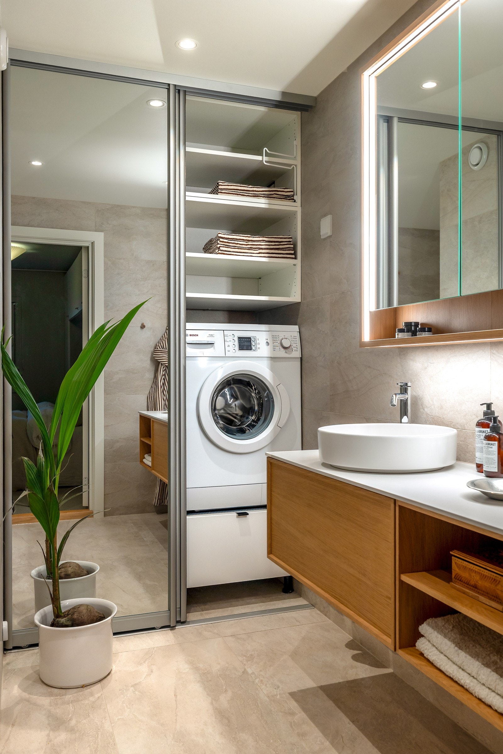 Det er opplegg for vaskemaskin og tørketrommel skjult bak praktiske skyvedører med speilfront Galleribilde