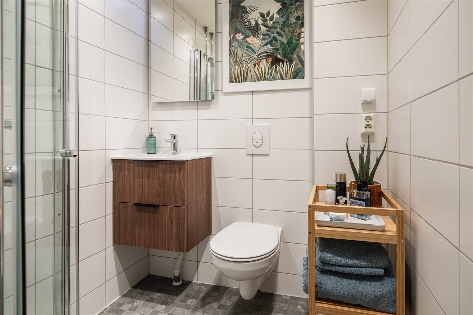 Badet er helfliset med vegghengt toalett og servant med underskap. Galleribilde