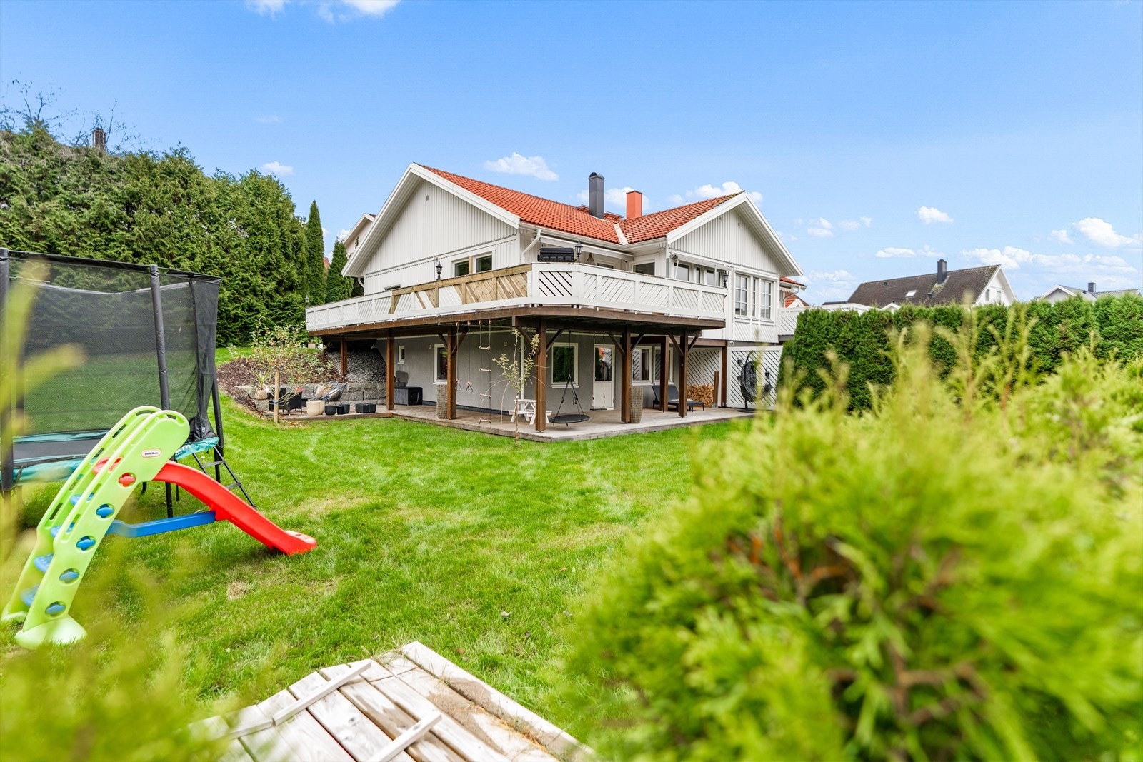Stor og solrik hage med rikelig boltreplass for både barn og voksne. Et perfekt uteområde for lek, avslapning og hagekos. Galleribilde