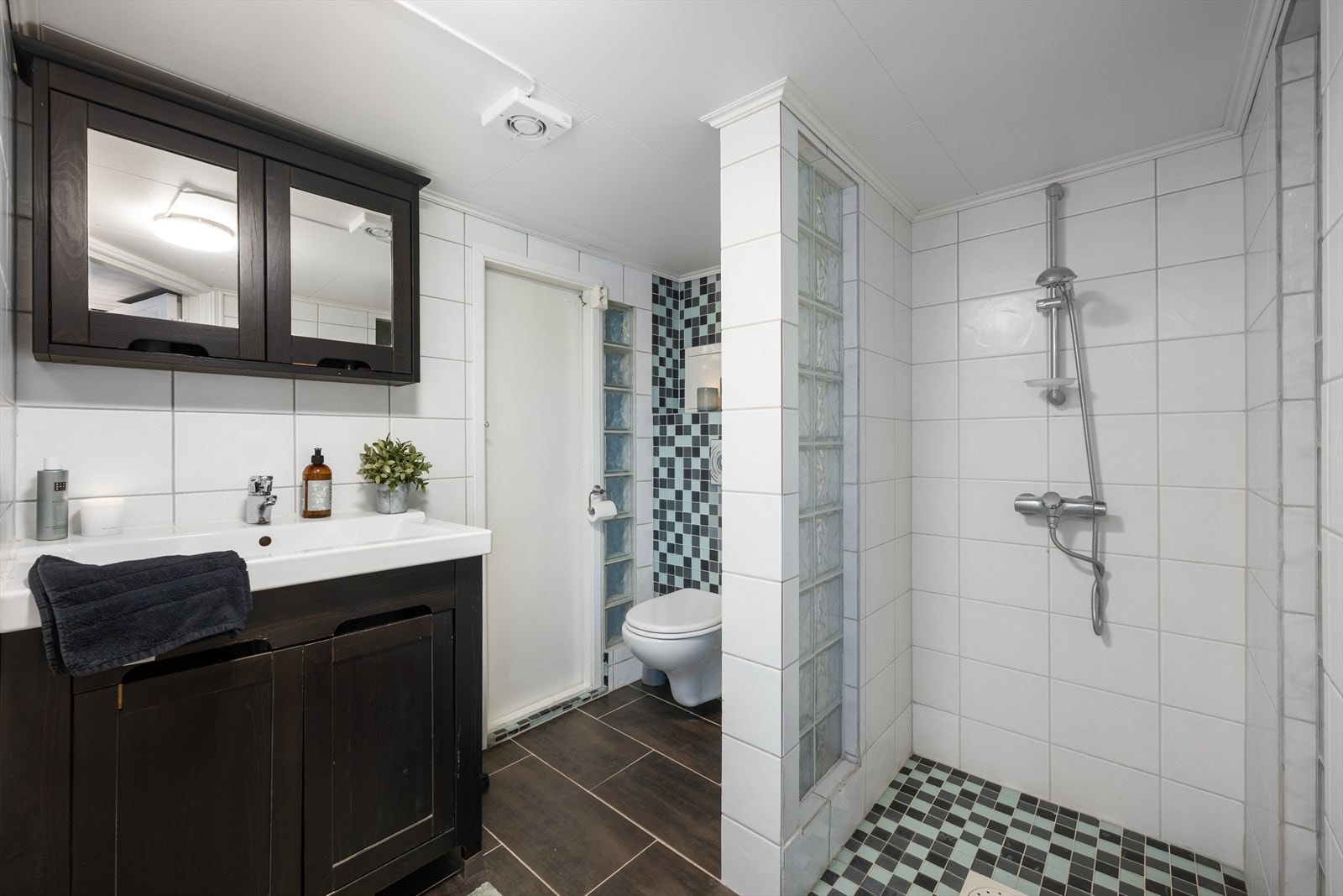 Bad/wc nede med fliser på gulv og vegg. Galleribilde