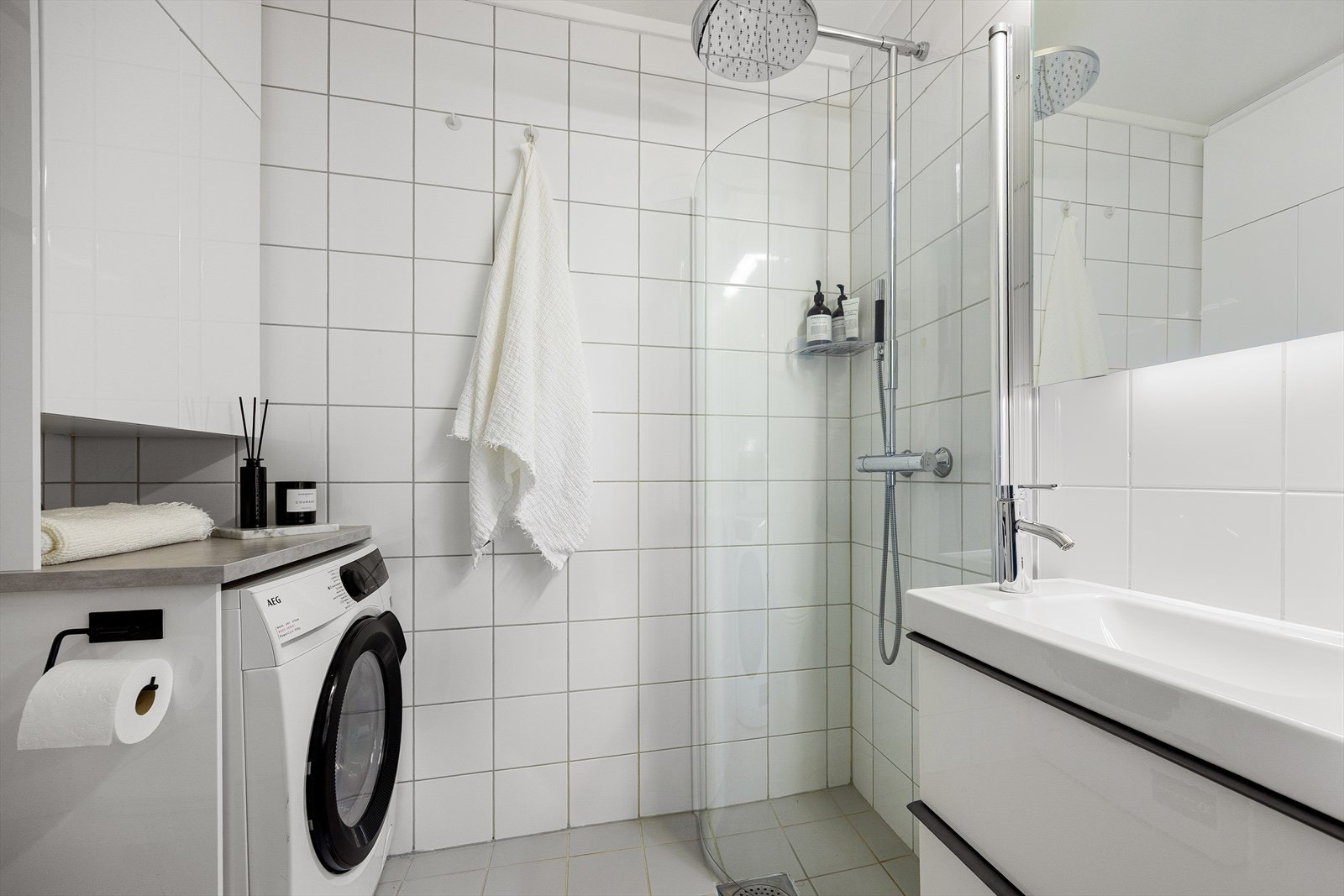 Lekkert flislagt bad med gulvvarme og opplegg til vaskemaskin Galleribilde