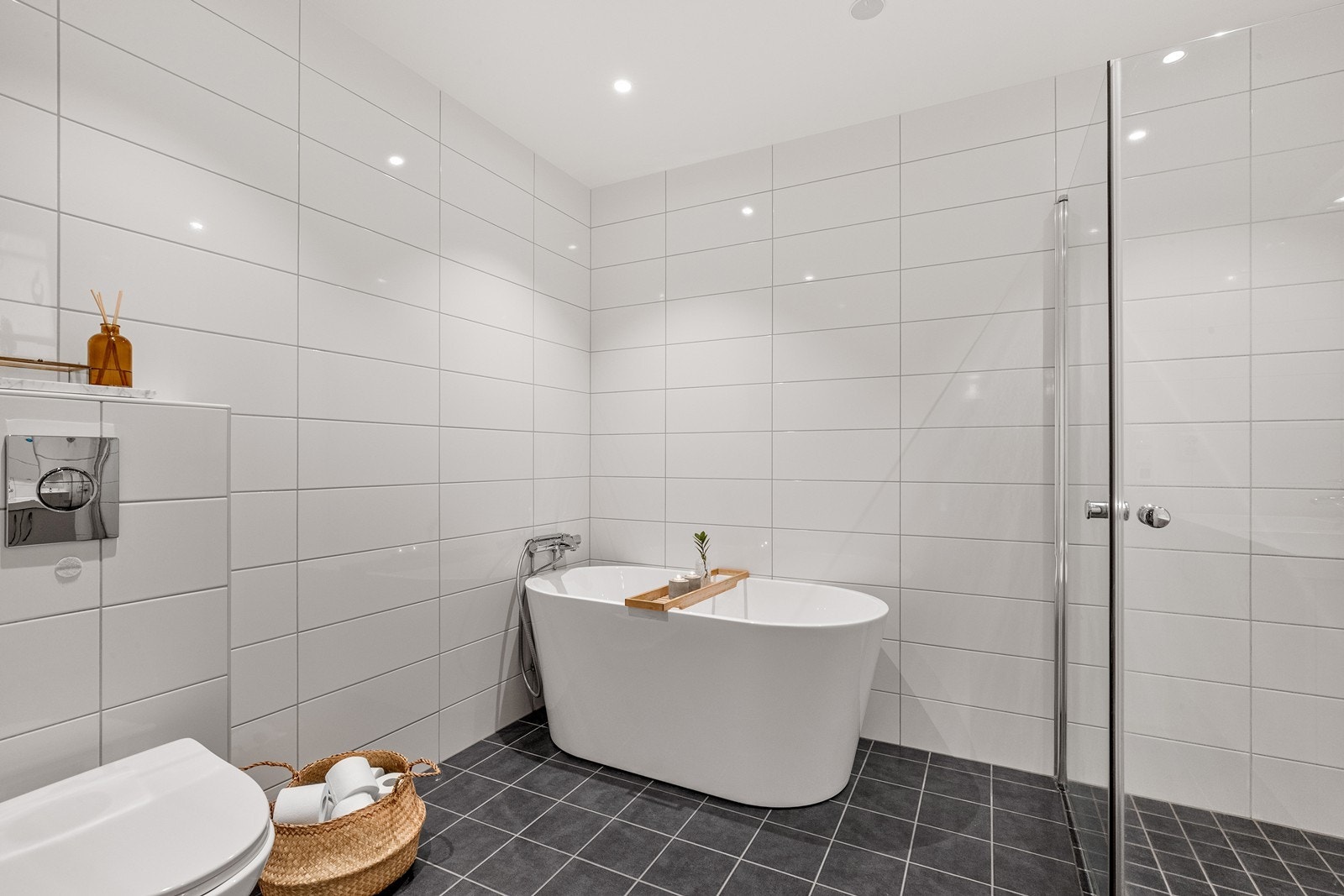 Boligens andre bad er også flislagt og har både frittstående badekar og dusjnisje. Galleribilde