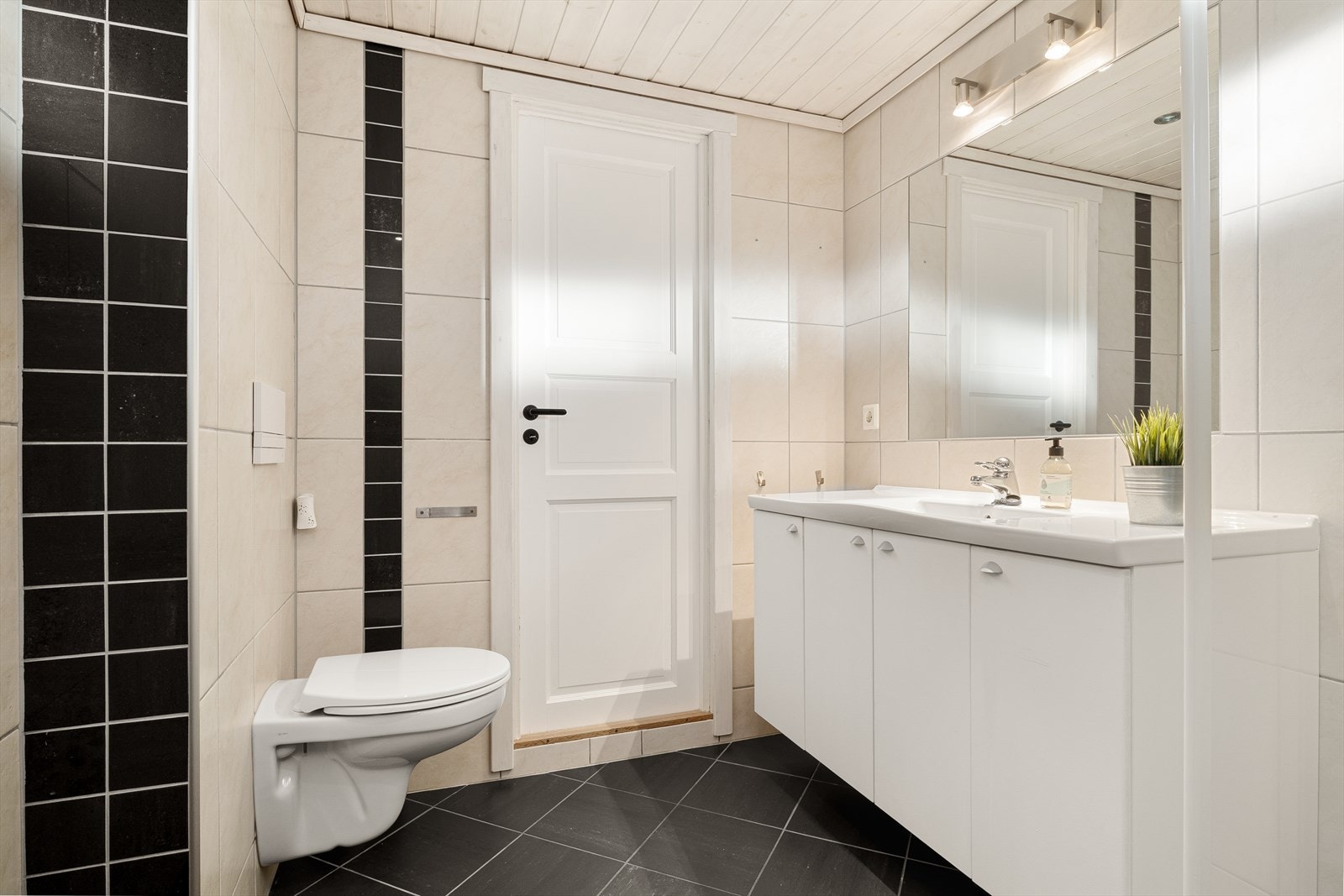 Badet har fliser på gulv og vegger, samt panel i himling. Det er elektrisk gulvvarme. Galleribilde