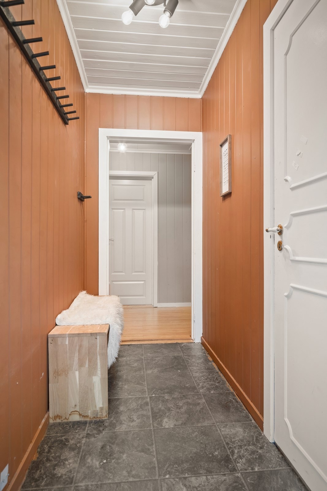Inne blir du møtt av en lys og innbydende gang med flislagt gulv. Her er det plass til ulike oppbevaringsløsninger. Galleribilde