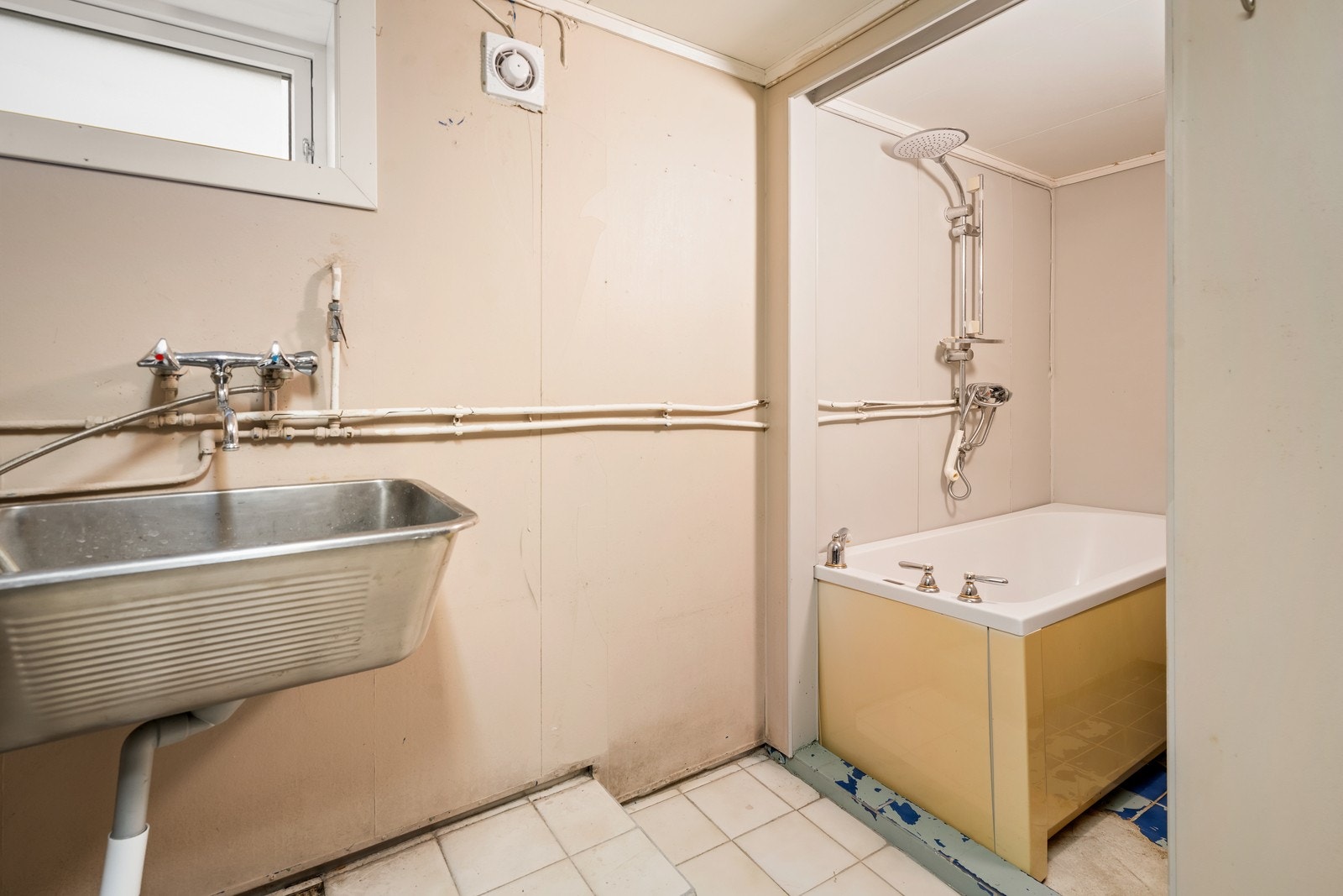 Rommet inneholder en skyllekum, et badekar og har opplegg for vaskemaskin, i tillegg til et toalett som ikke er tilkoblet. Galleribilde