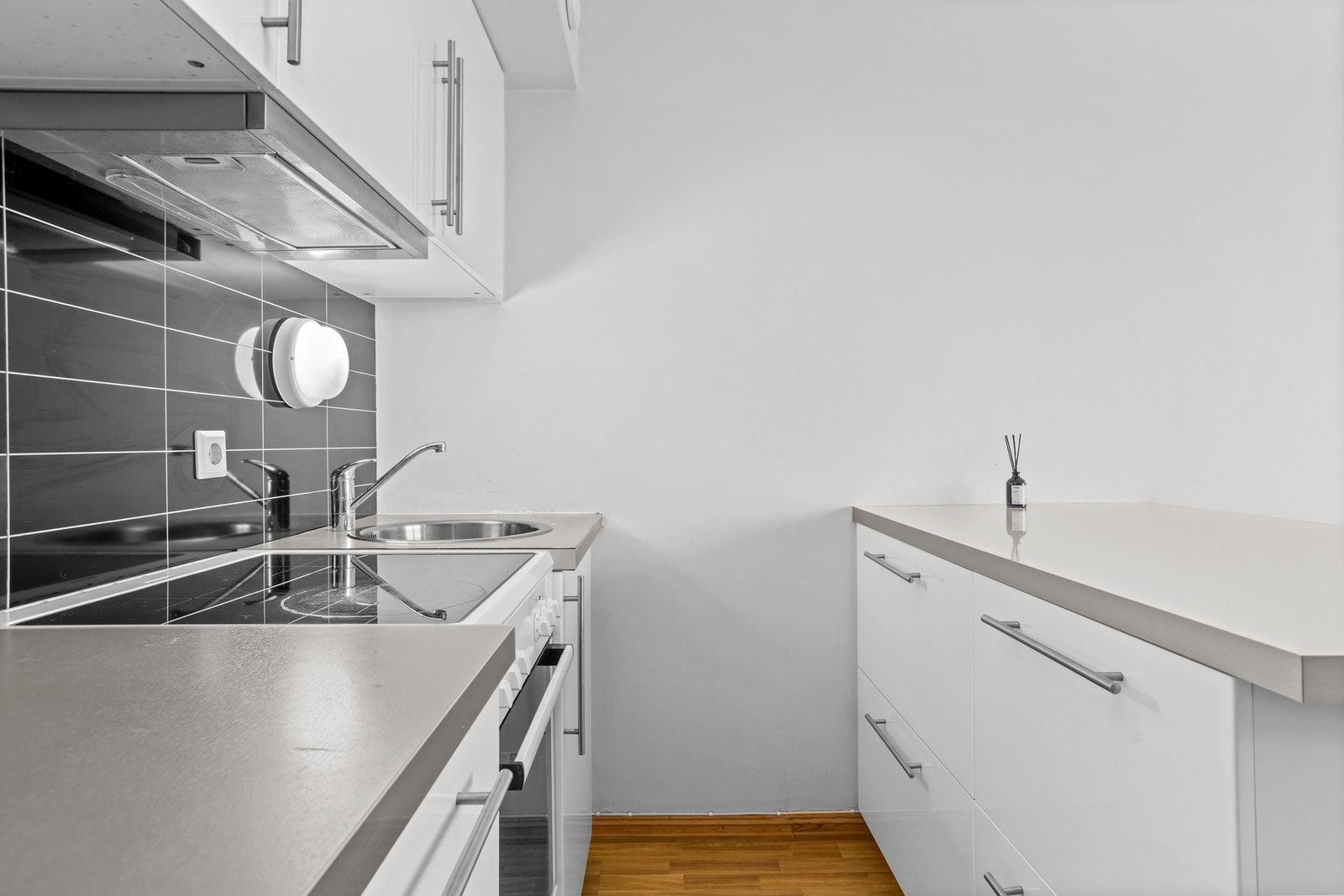 Kjøkkenet har et stilrent og arealeffektivt design med god skap- og benkeplass og en romslig kjøkkenøy. Galleribilde