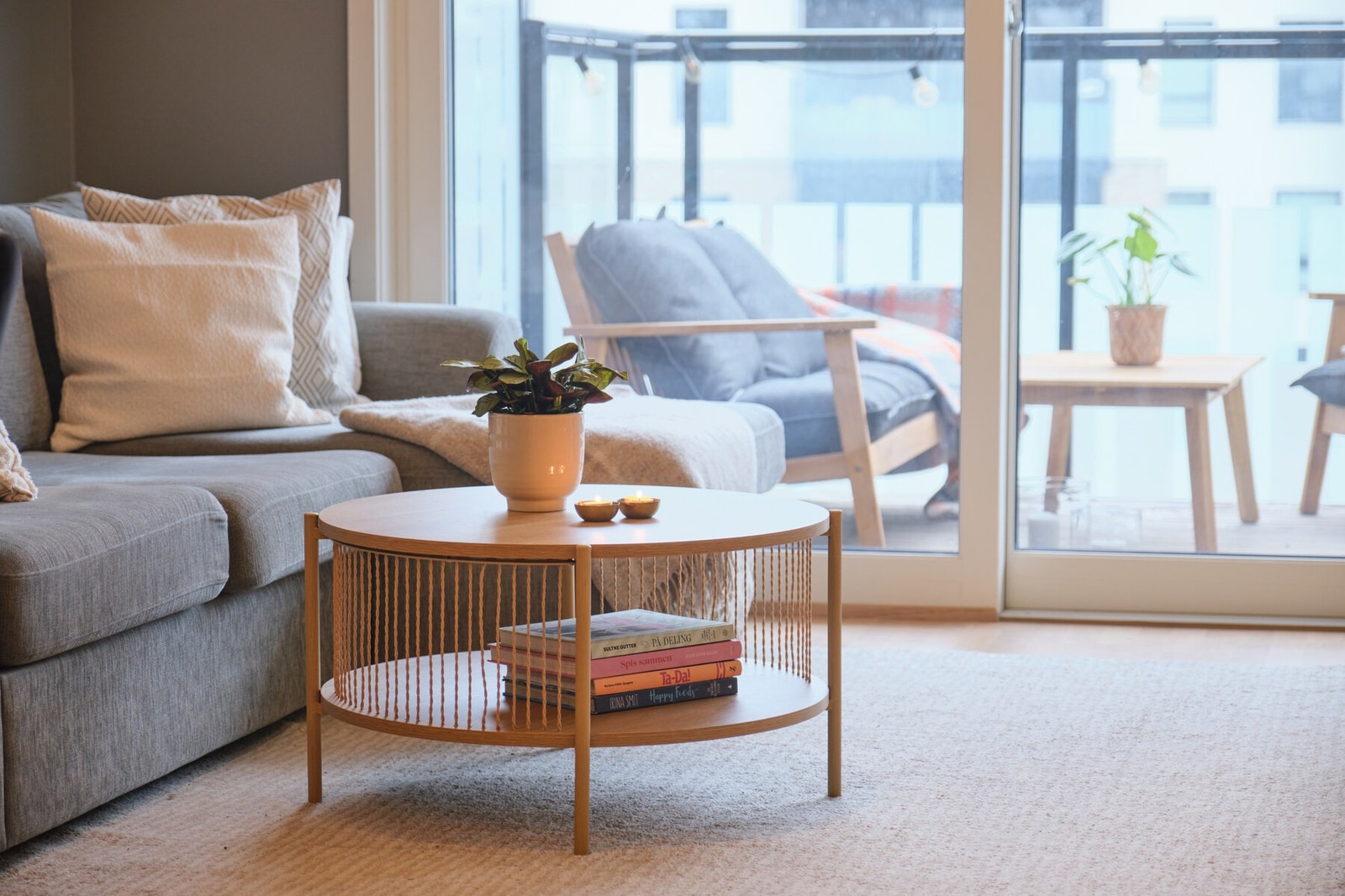 Inn til en lys stue med store vindusflater og skyvedør ut til en stor balkong Galleribilde