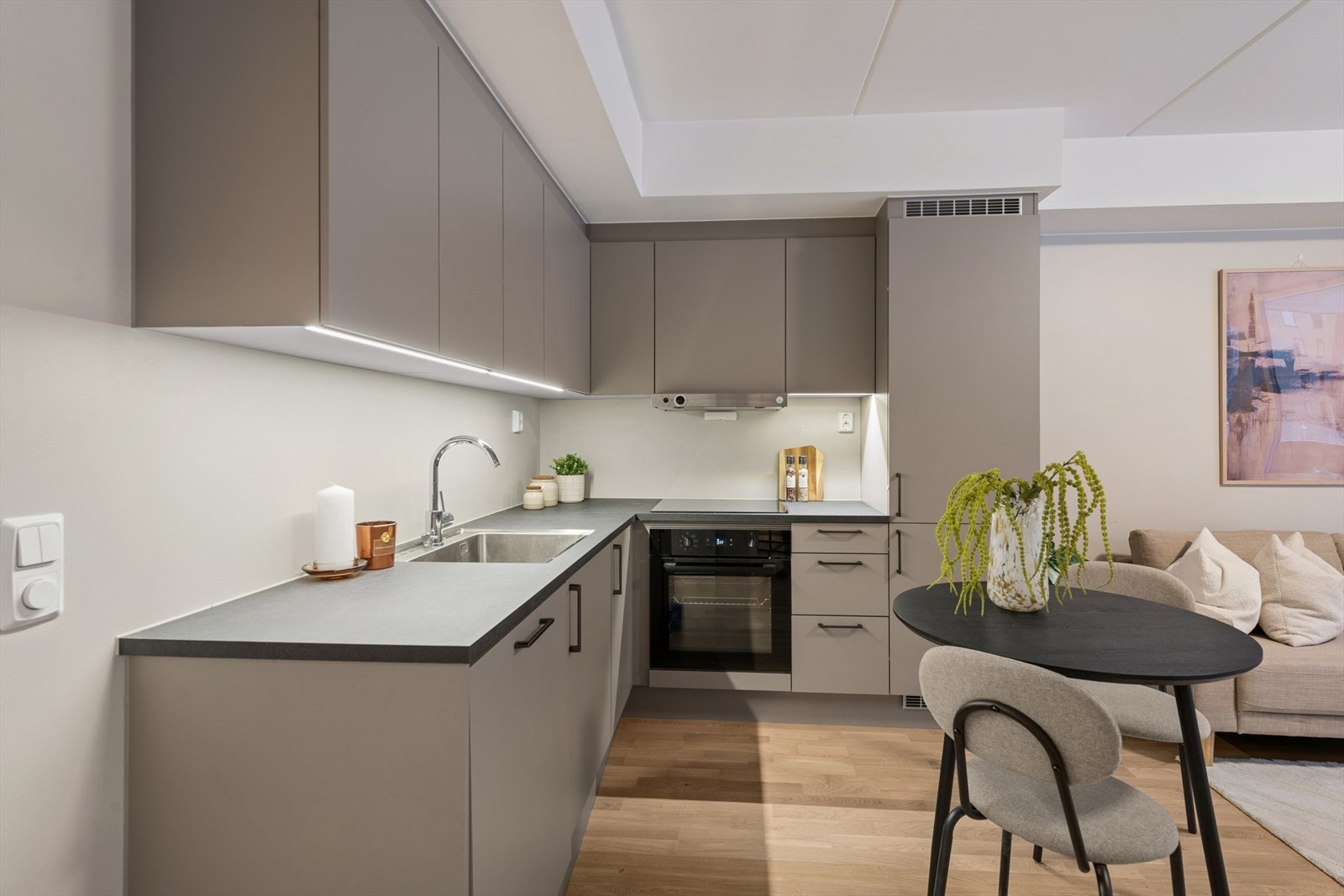 Kjøkkenet har glatte, folierte fronter som gir et moderne uttrykk, samt en slitesterk laminert benkeplate med nedfelt kum i rustfritt stål. Galleribilde