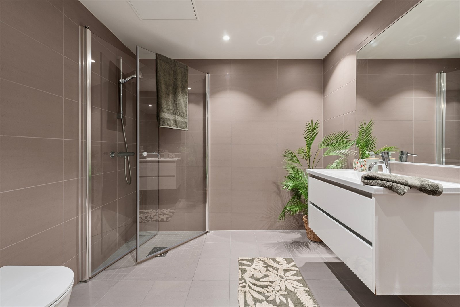 Lekkert, helfliset bad med behagelig gulvvarme. Her er det opplegg for vaskemaskin. Galleribilde