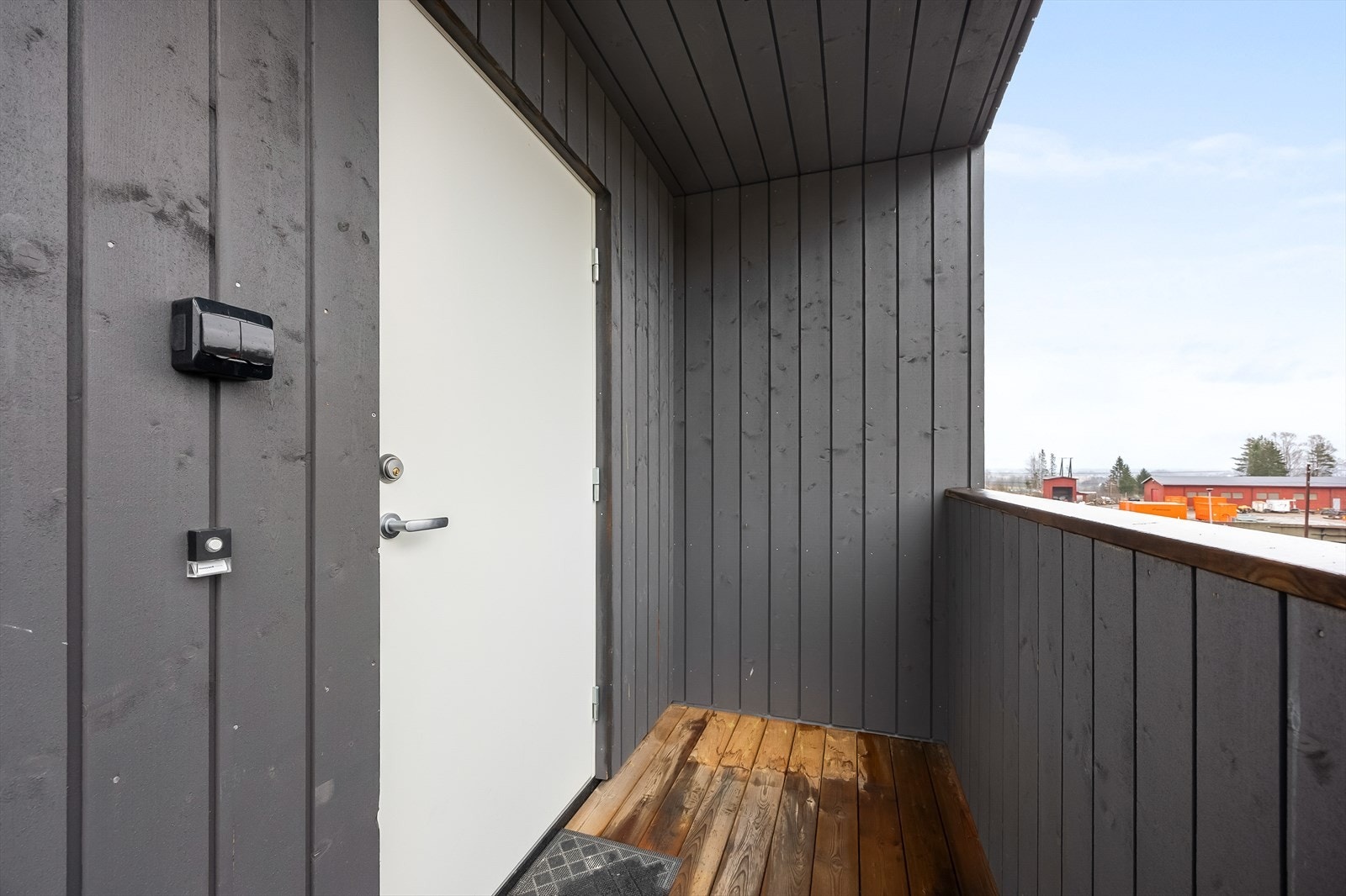 En overbygd svalgang med utvendig trapp fører opp til leilighetens inngangsparti. Galleribilde