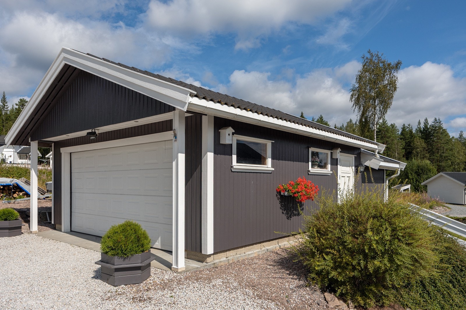 Det er parkering i en frittliggende dobbelgarasje og på den gruslagte gårdsplassen. Garasjen har elbillader, motorisert port og 2 lagringsboder. Galleribilde