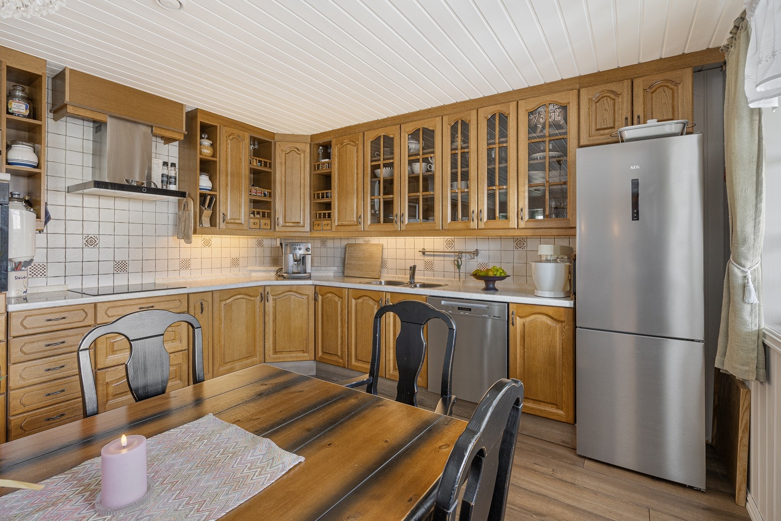 Veggene over benken er kledd med lyse fliser, og under overskapene er det montert god arbeidsbelysning. Galleribilde