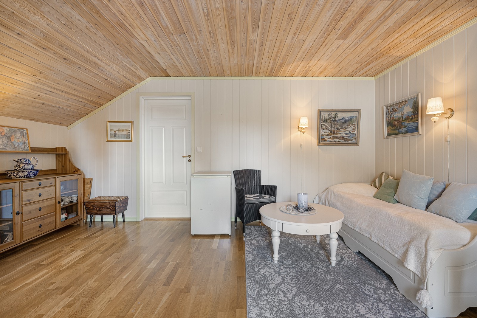 I loftsetasjen er det et innredet rom benyttet som loftstue. Veggene er lysmalte, og det er gyllen, trestavs parkett på gulvet. Galleribilde