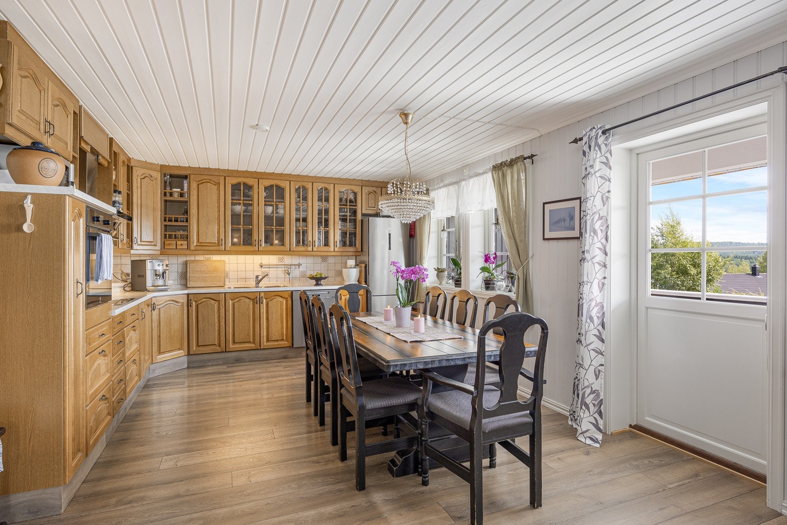 Videre er kjøkkenet utstyrt med integrert oppvaskmaskin, kjøl-/fryseskap, stekeovn og induksjonstopp, samt kullfilterventilator og flere benkestikk. Galleribilde